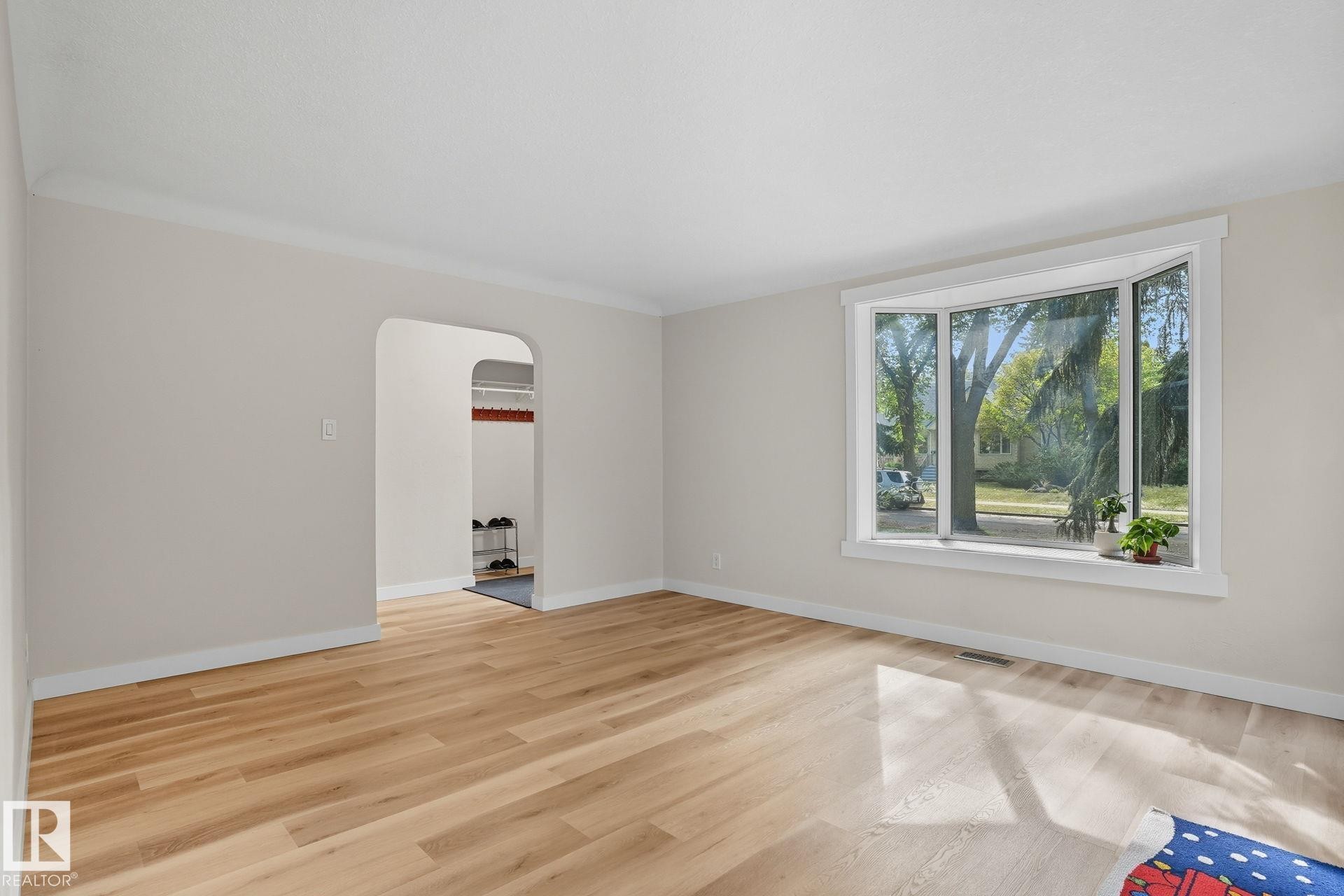 Empty room featuring arched walkways and light wood-type flooring - 11222 71 Avenue, Edmonton, AB - Indoor Photo Showing Other Room
