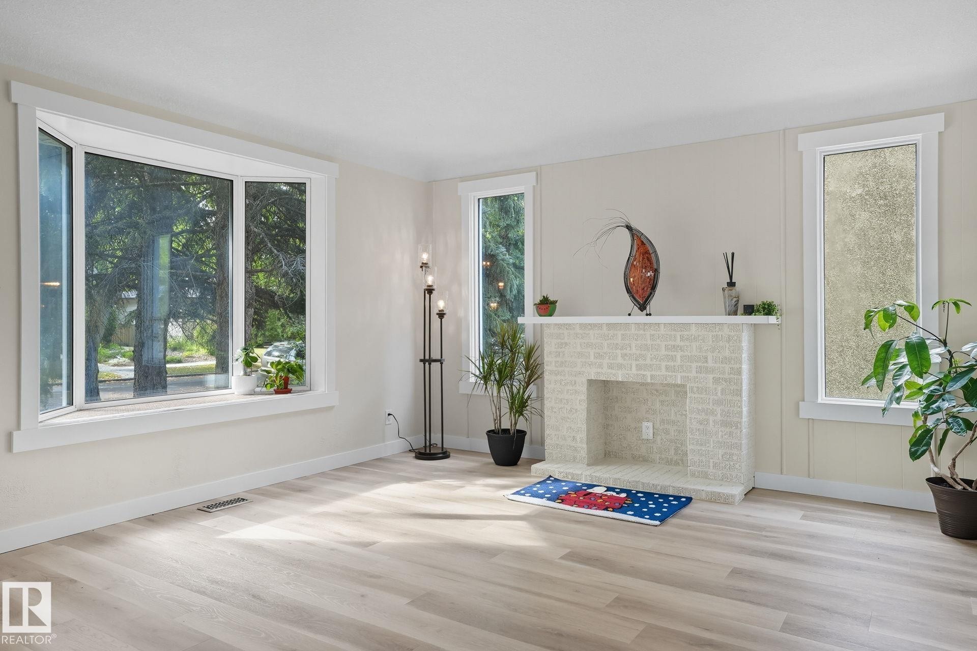Unfurnished living room with wood finished floors, healthy amount of natural light, and a fireplace - 11222 71 Avenue, Edmonton, AB - Indoor Photo Showing Other Room