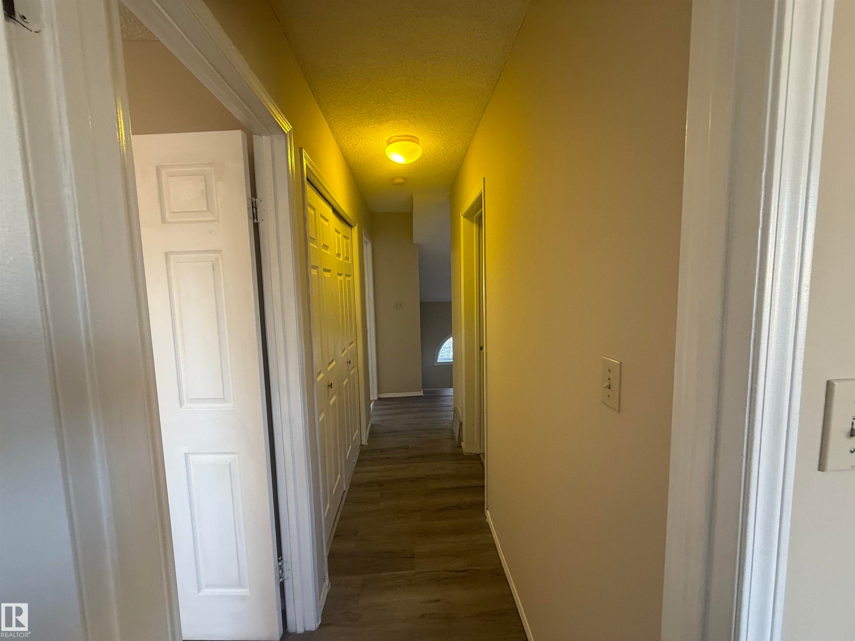 Corridor with dark wood-style flooring and a textured ceiling - 10905 74 Avenue, Edmonton, AB - Indoor Photo Showing Other Room