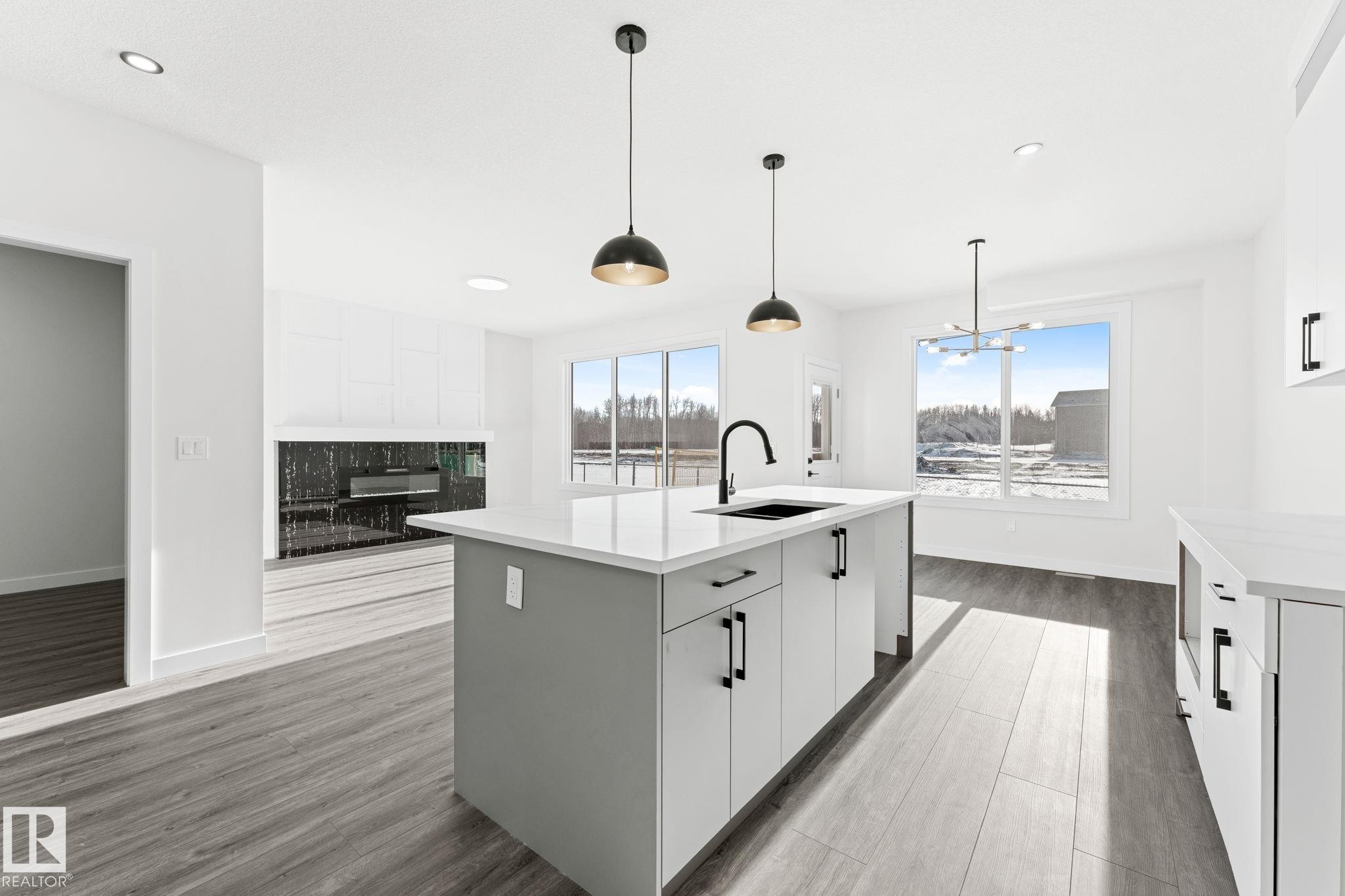 Kitchen with a center island with sink, white cabinets, and light wood-style floors - 3 Pierwyck Loop, Spruce Grove, AB - Indoor Photo Showing Kitchen With Upgraded Kitchen
