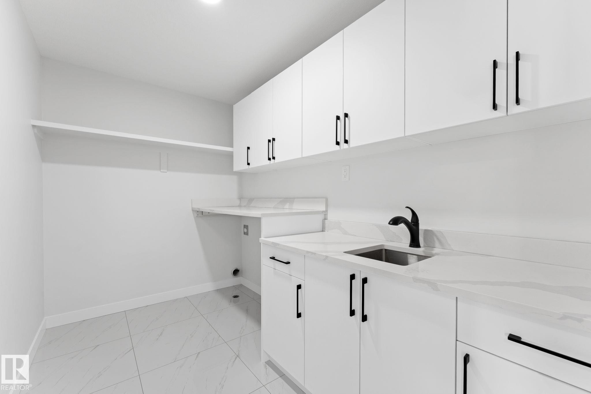 Laundry room featuring cabinet space and light marble finish flooring - 3 Pierwyck Loop, Spruce Grove, AB - Indoor Photo Showing Kitchen