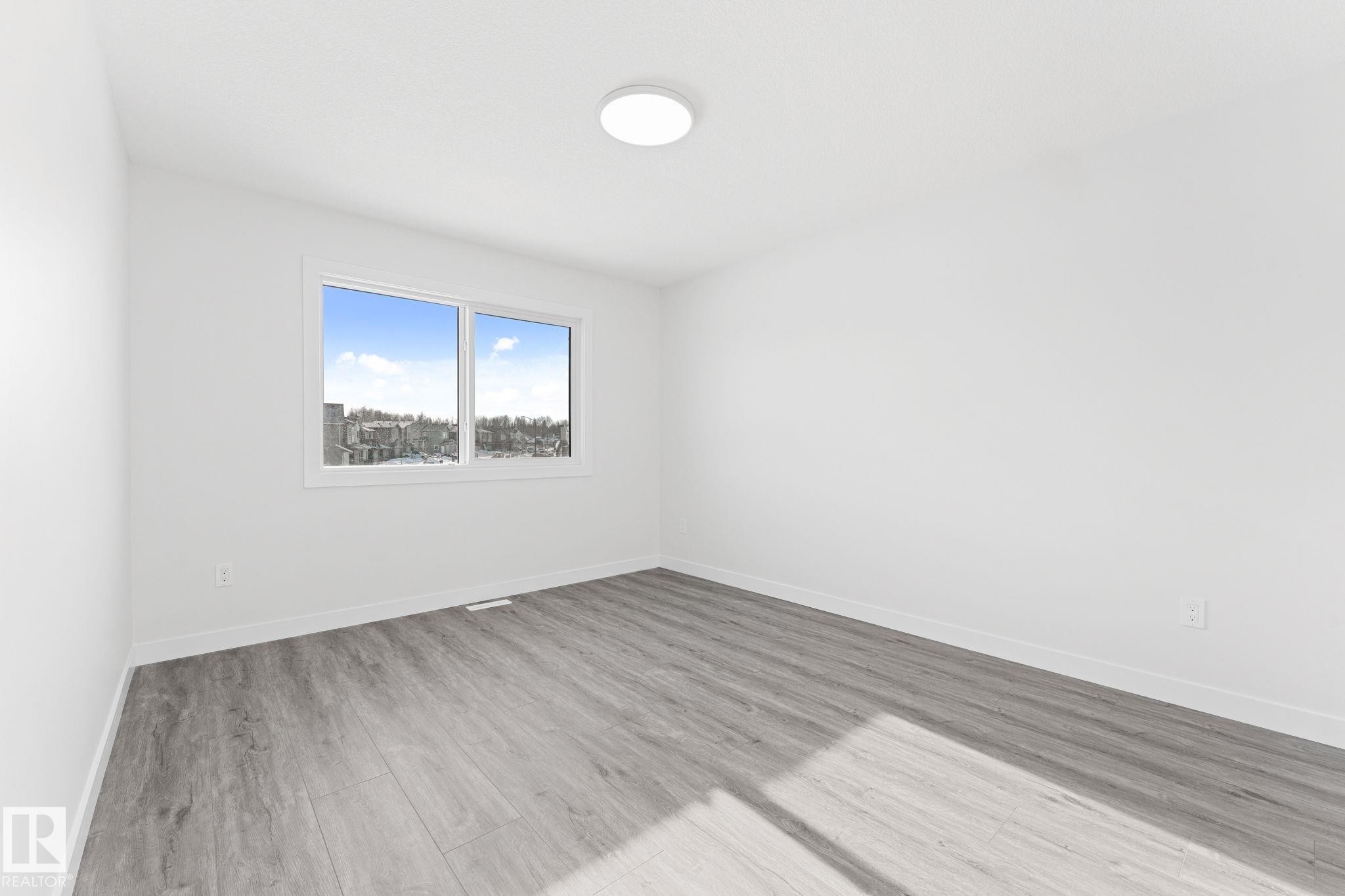 Empty room with baseboards and light wood-style floors - 3 Pierwyck Loop, Spruce Grove, AB - Indoor Photo Showing Other Room