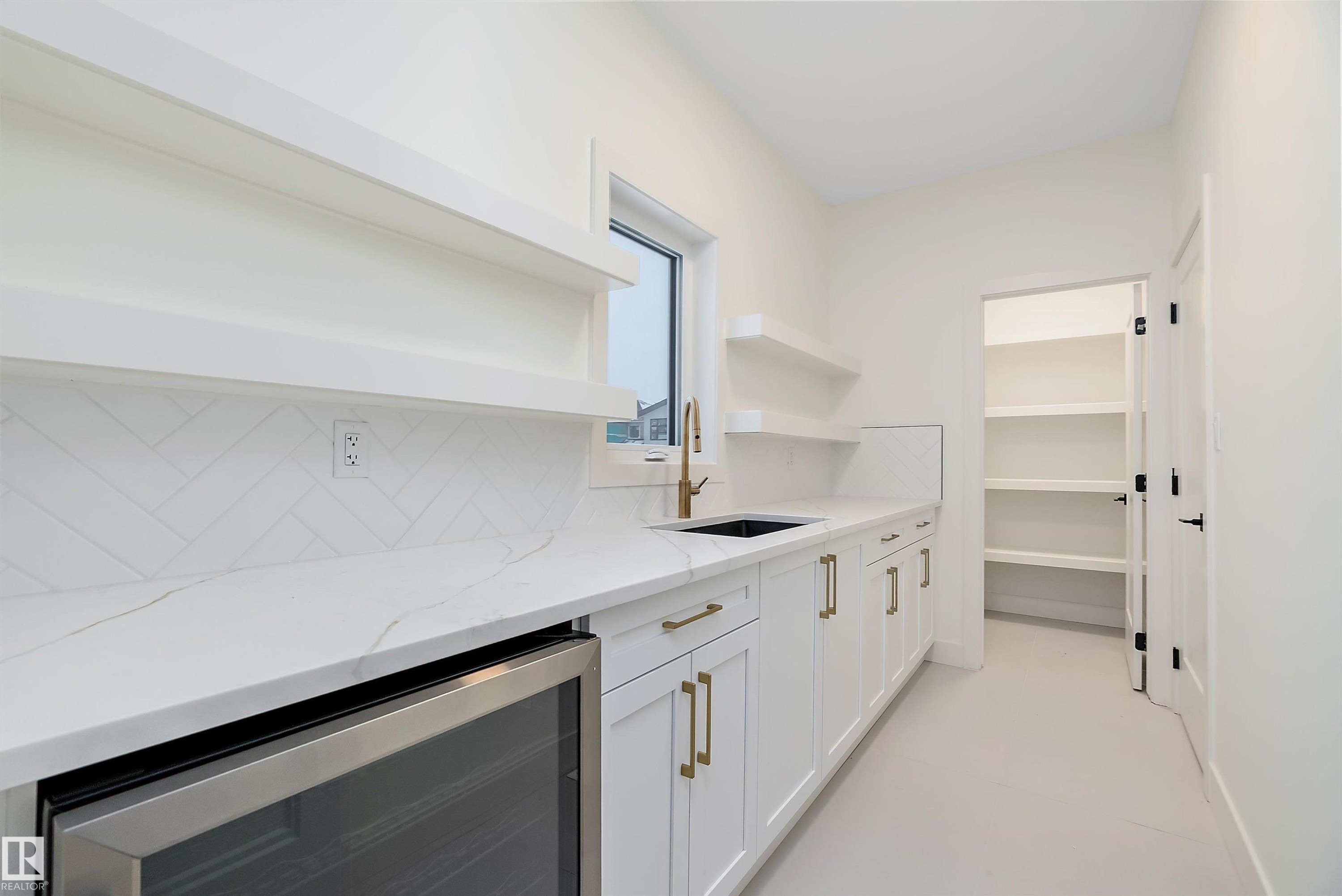 Bar area with open shelves, beverage cooler, white cabinets, light stone countertops, and backsplash - Edmonton, AB - Indoor Photo Showing Kitchen