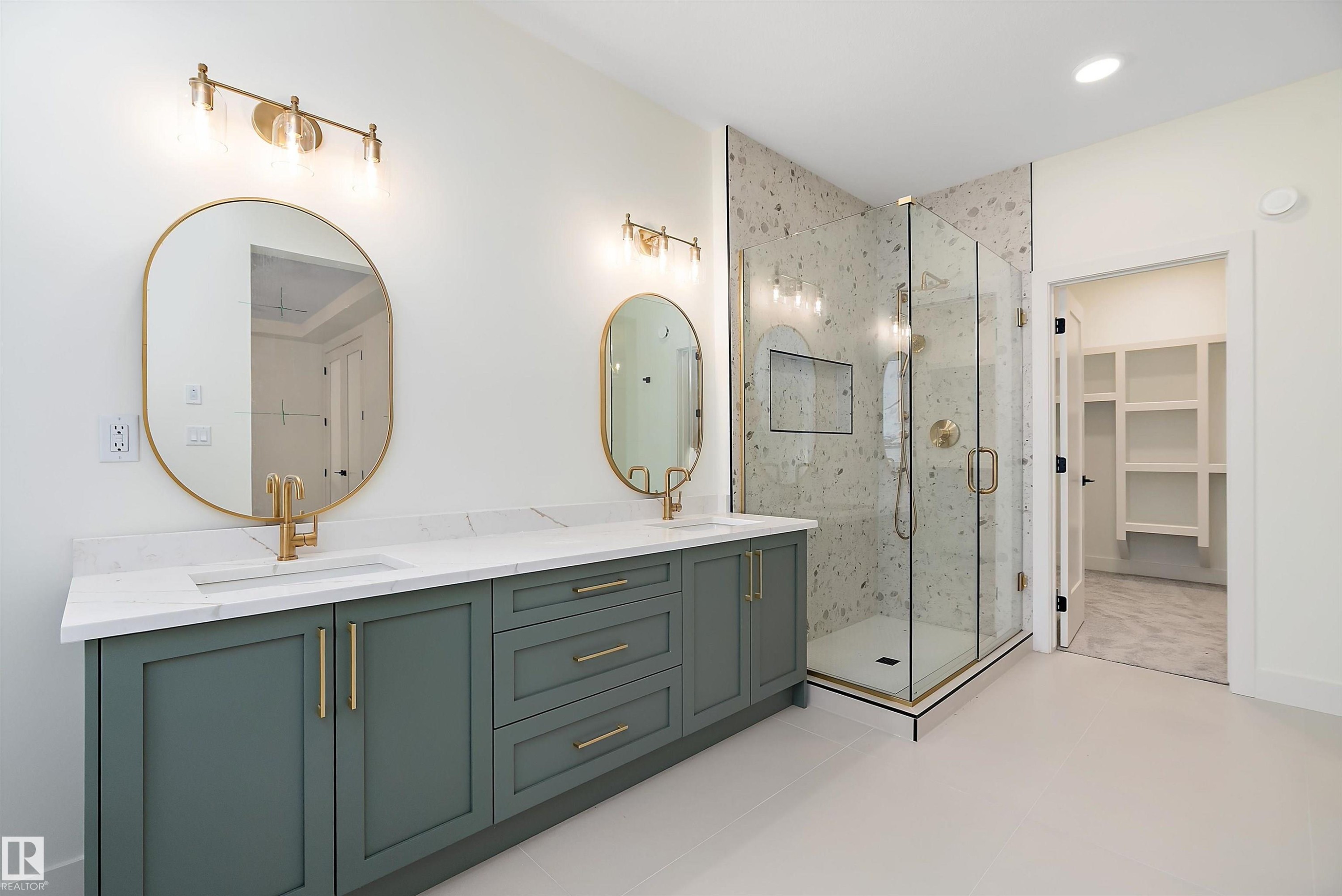 Full bathroom with a spacious closet, a marble finish shower, double vanity, and light tile patterned floors - Edmonton, AB - Indoor Photo Showing Bathroom