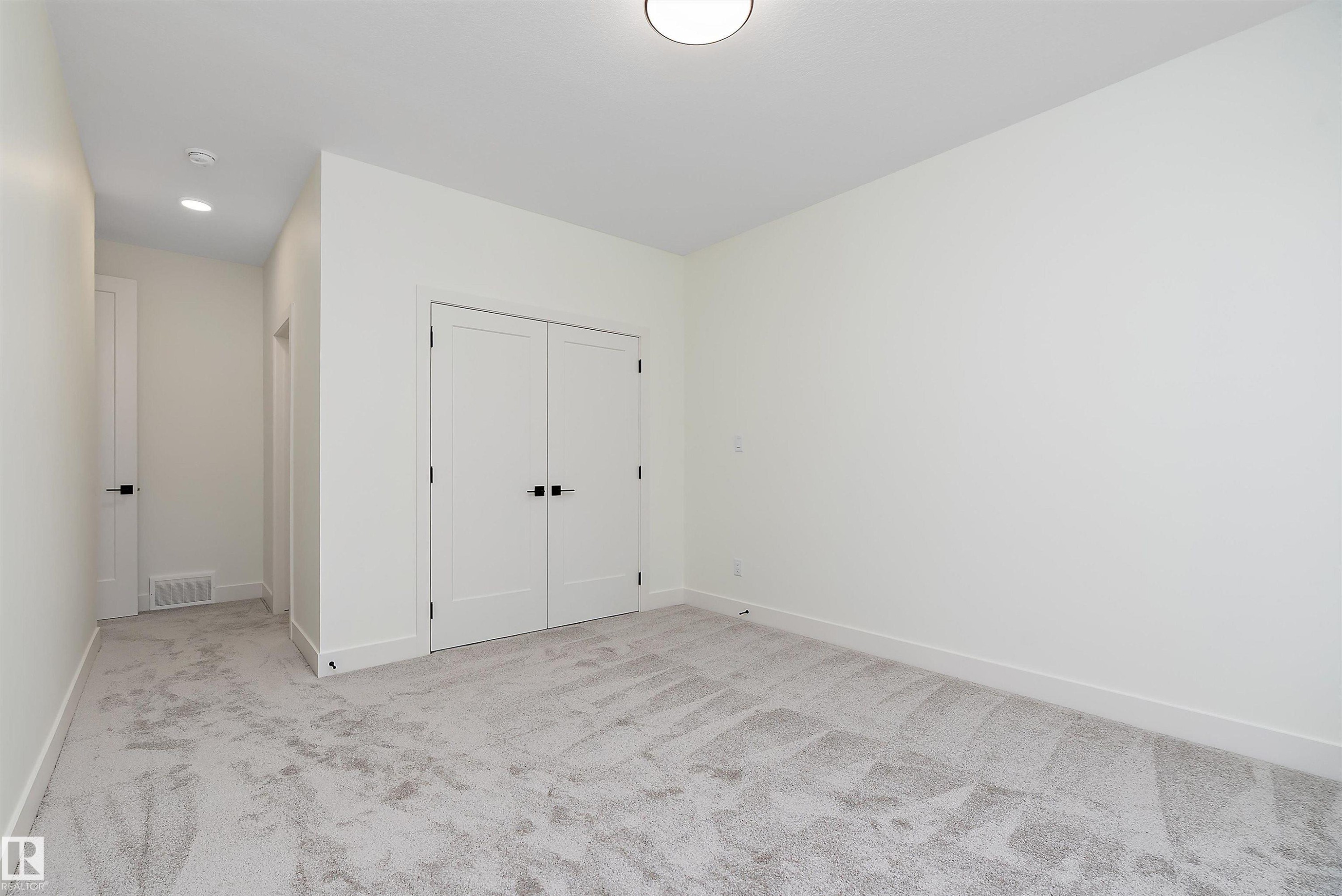 Unfurnished bedroom featuring light colored carpet, a closet, and recessed lighting - Edmonton, AB - Indoor Photo Showing Other Room