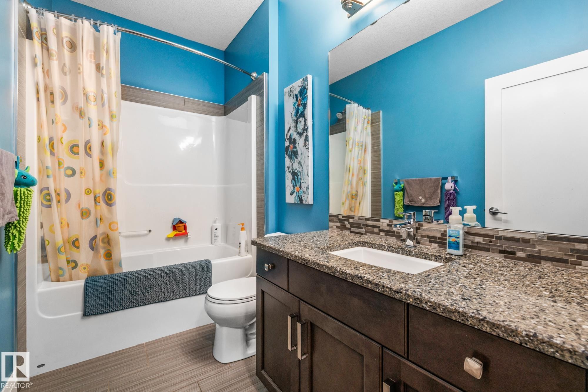 Full bath with vanity, shower / bathtub combination with curtain, and decorative backsplash - 14 Spring Bay, Spruce Grove, AB - Indoor Photo Showing Bathroom