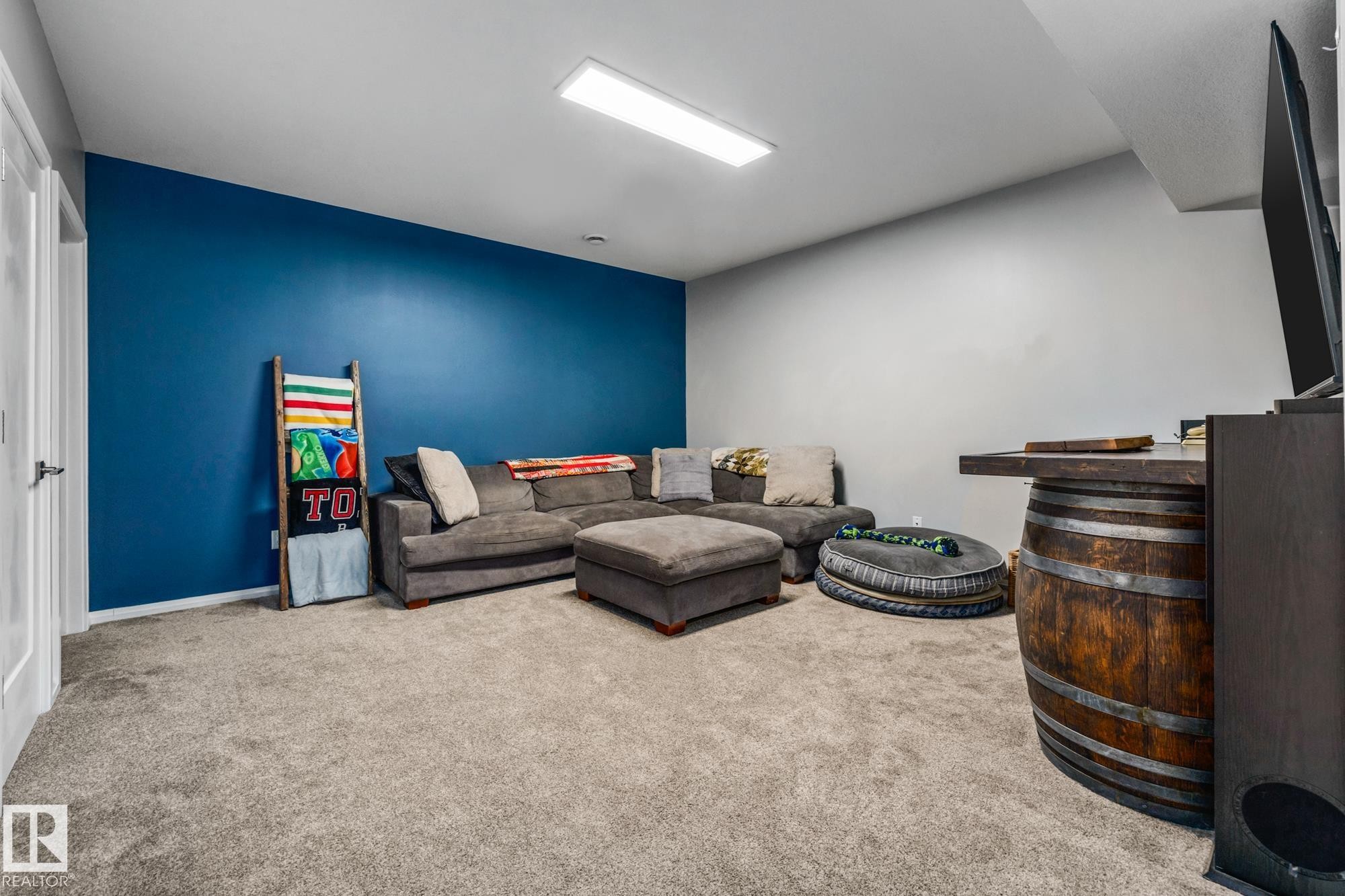 Living room featuring light carpet and an accent wall - 14 Spring Bay, Spruce Grove, AB - Indoor