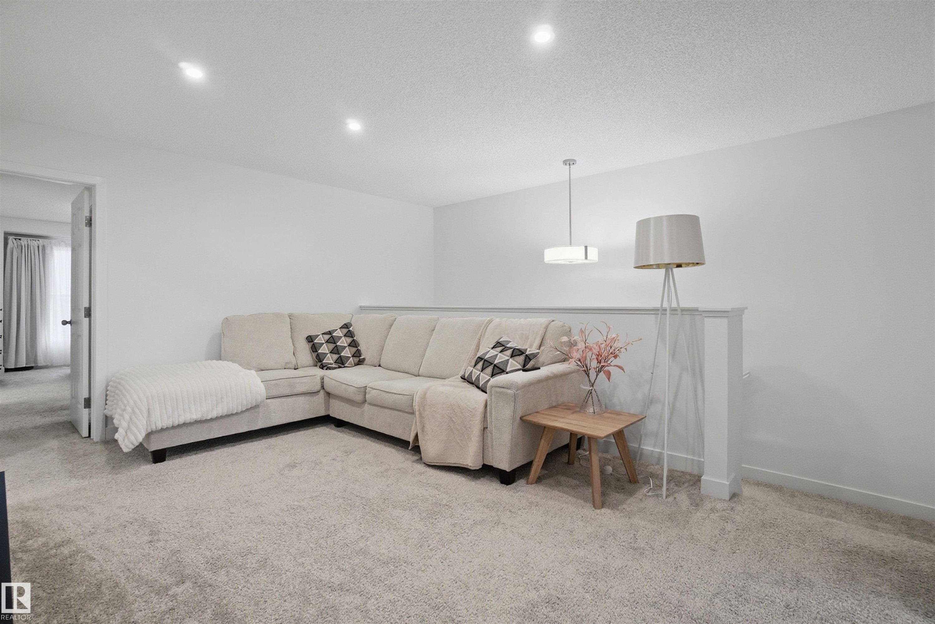 Carpeted living room with baseboards and a textured ceiling - 9882 225A St Nw, Edmonton, AB - Indoor