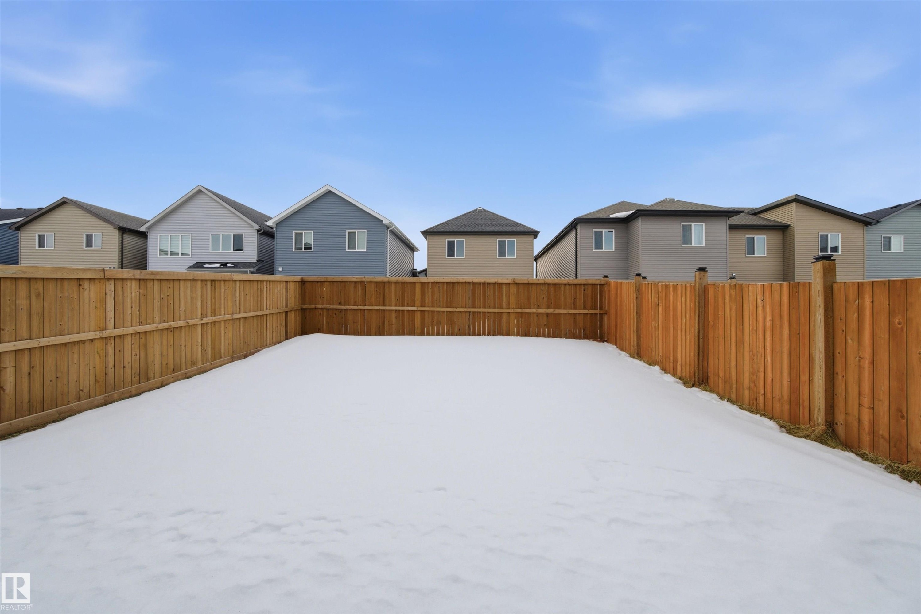 Yard covered in snow with a residential view and a fenced backyard - 9882 225A St Nw, Edmonton, AB - Outdoor With Exterior