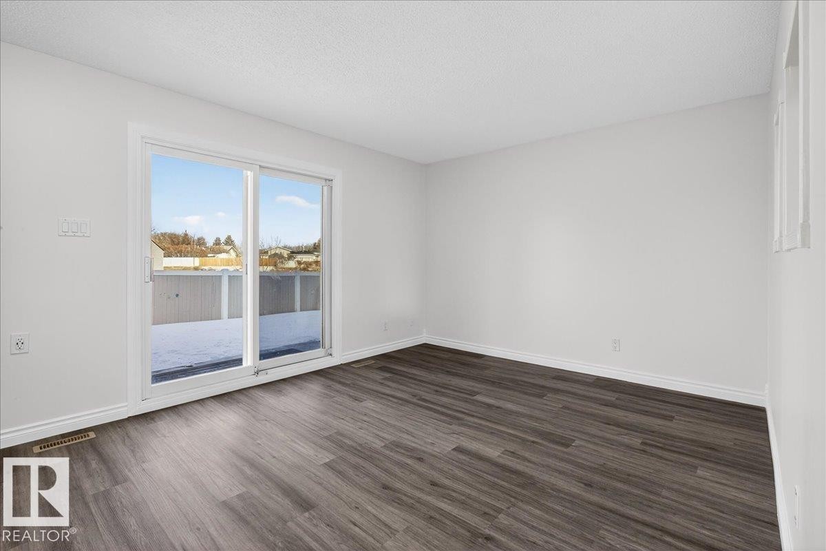 Empty room with dark wood-style floors and a textured ceiling - 133 Habitat Crescent, Edmonton, AB - Indoor Photo Showing Other Room