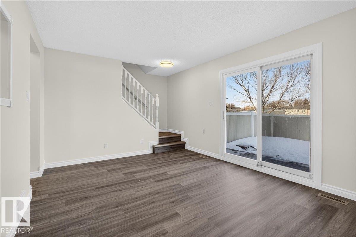 Unfurnished living room with stairway and wood finished floors - 133 Habitat Crescent, Edmonton, AB - Indoor Photo Showing Other Room
