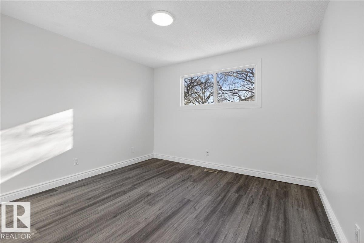 Spare room featuring dark wood-type flooring and a textured ceiling - 133 Habitat Crescent, Edmonton, AB - Indoor Photo Showing Other Room