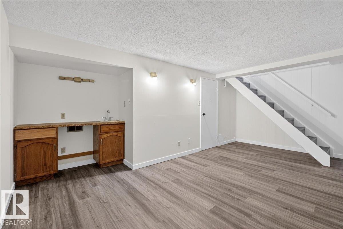 Unfurnished living room with a textured ceiling and light wood finished floors - 133 Habitat Crescent, Edmonton, AB - Indoor Photo Showing Other Room