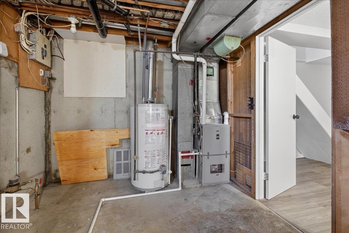 Utilities featuring water heater, heating unit, and electric panel - 133 Habitat Crescent, Edmonton, AB - Indoor Photo Showing Basement