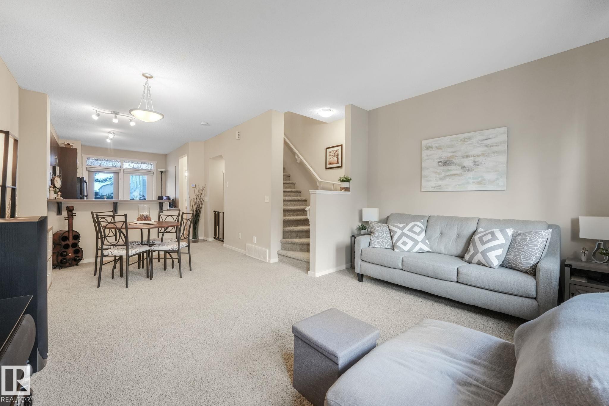 Living room featuring stairs and carpet - 91 603 Watt Boulevard, Edmonton, AB - Indoor Photo Showing Living Room