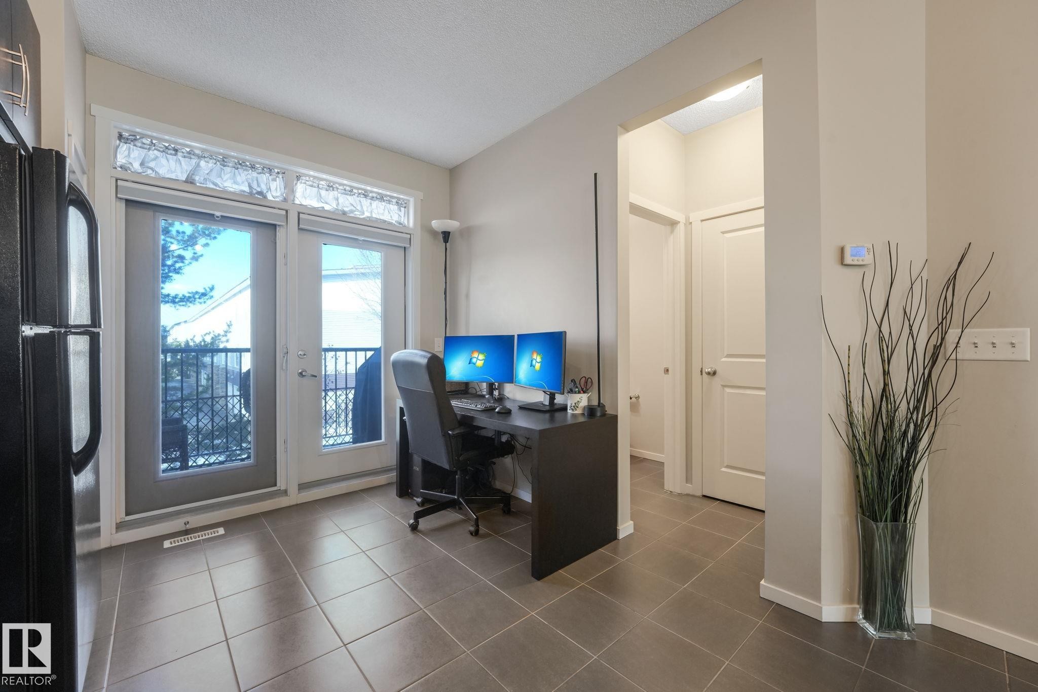 Office area featuring dark tile patterned flooring and a textured ceiling - 91 603 Watt Boulevard, Edmonton, AB - Indoor Photo Showing Office
