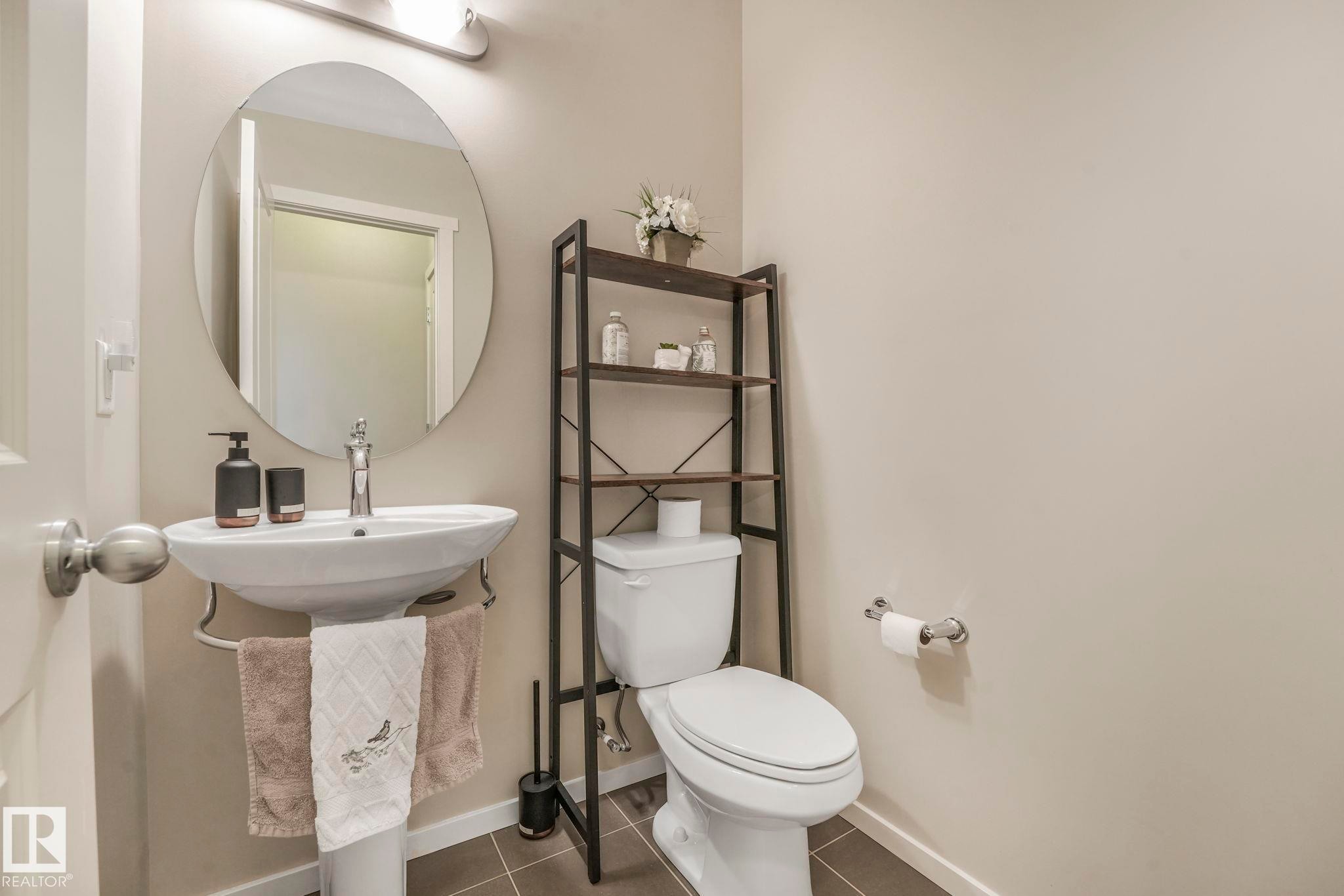 Bathroom with toilet and dark tile patterned flooring - 91 603 Watt Boulevard, Edmonton, AB - Indoor Photo Showing Bathroom