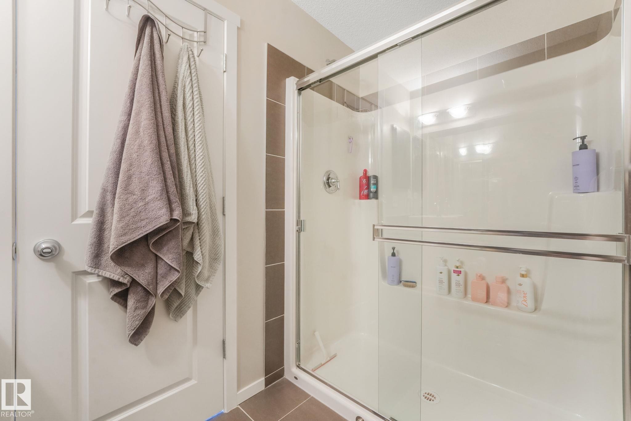 Bathroom featuring a stall shower and dark tile patterned floors - 91 603 Watt Boulevard, Edmonton, AB - Indoor Photo Showing Bathroom