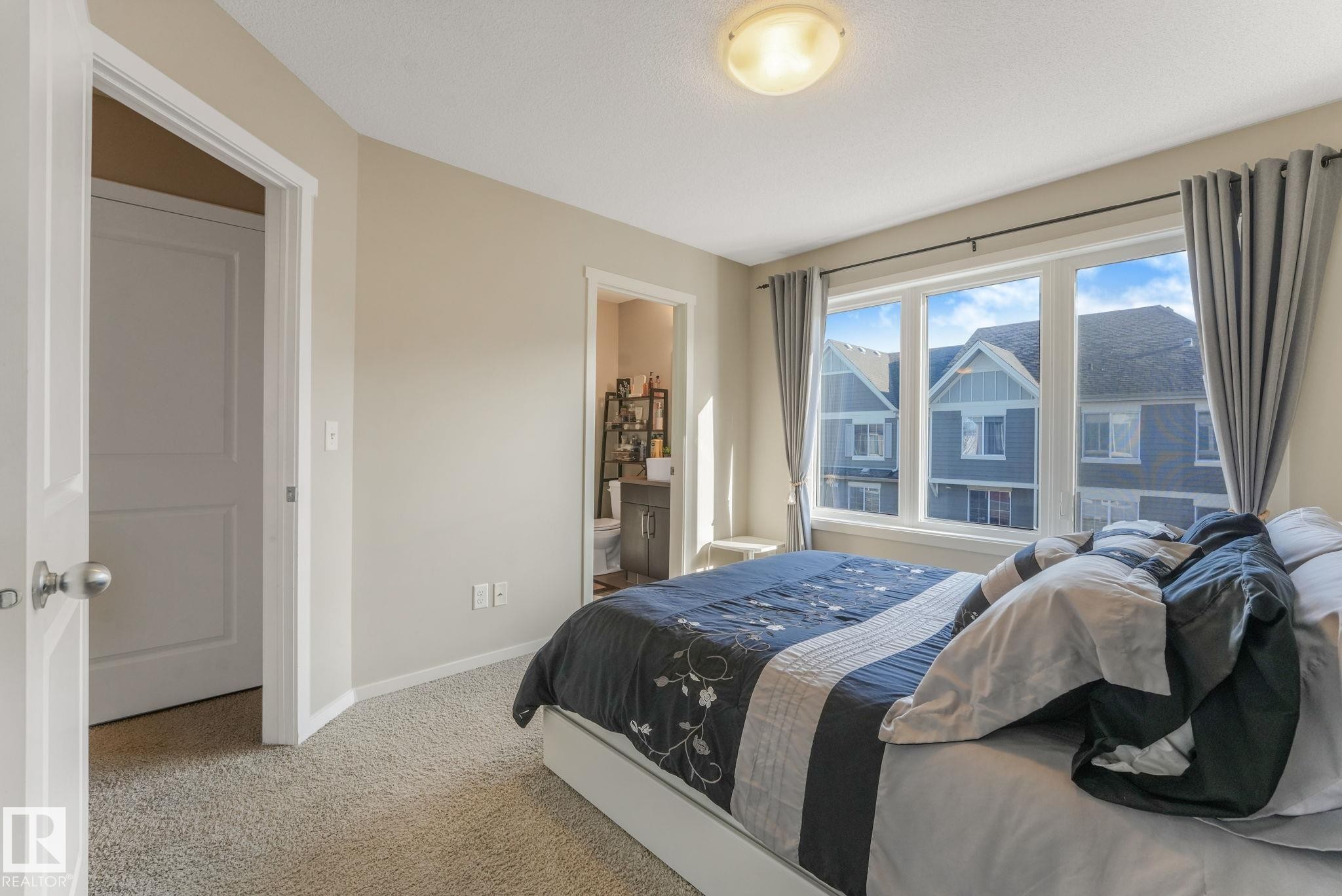 Carpeted bedroom with connected bathroom and baseboards - 91 603 Watt Boulevard, Edmonton, AB - Indoor Photo Showing Bedroom