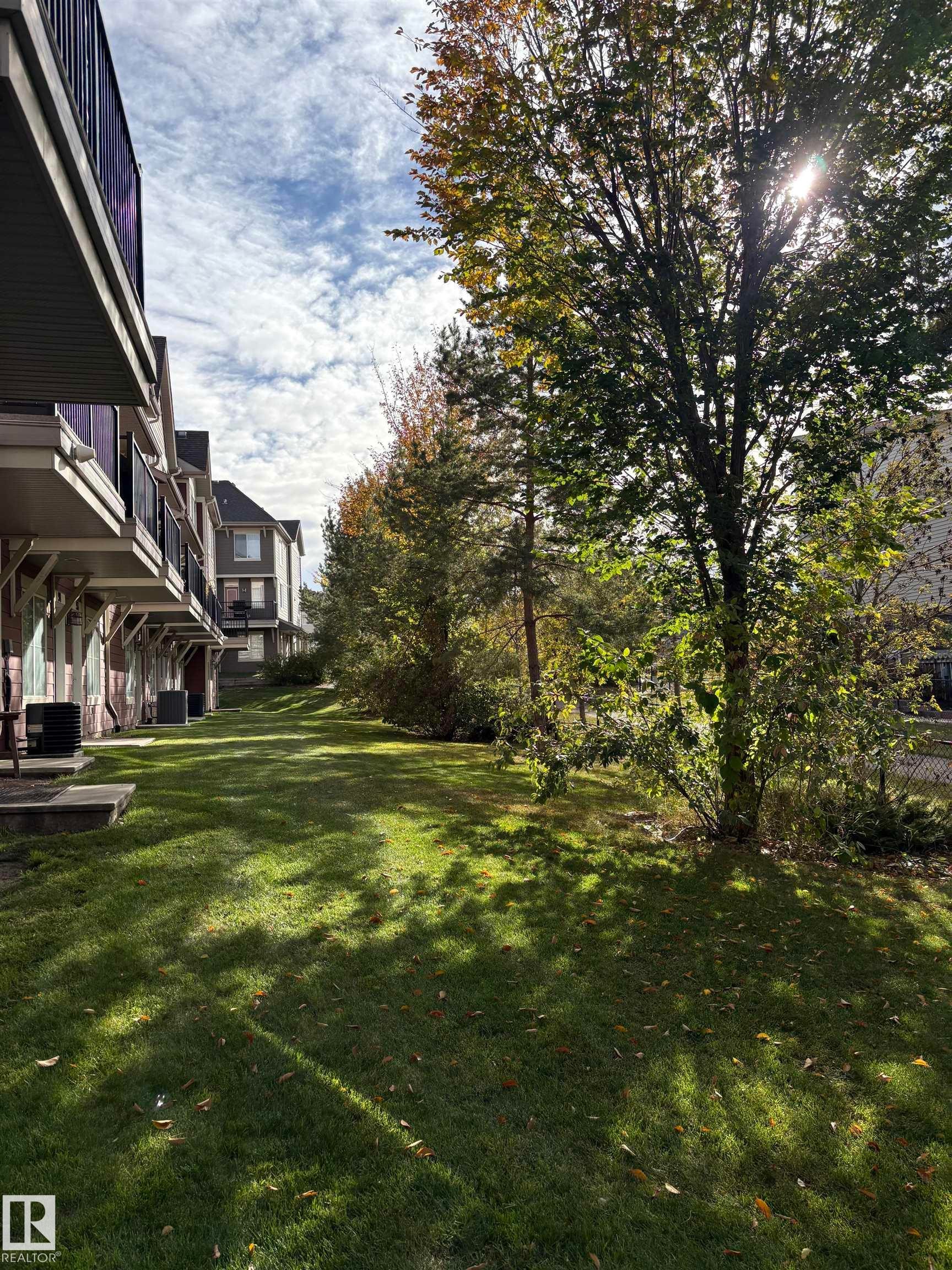 View of green lawn with a wooden deck - 91 603 Watt Boulevard, Edmonton, AB - Outdoor