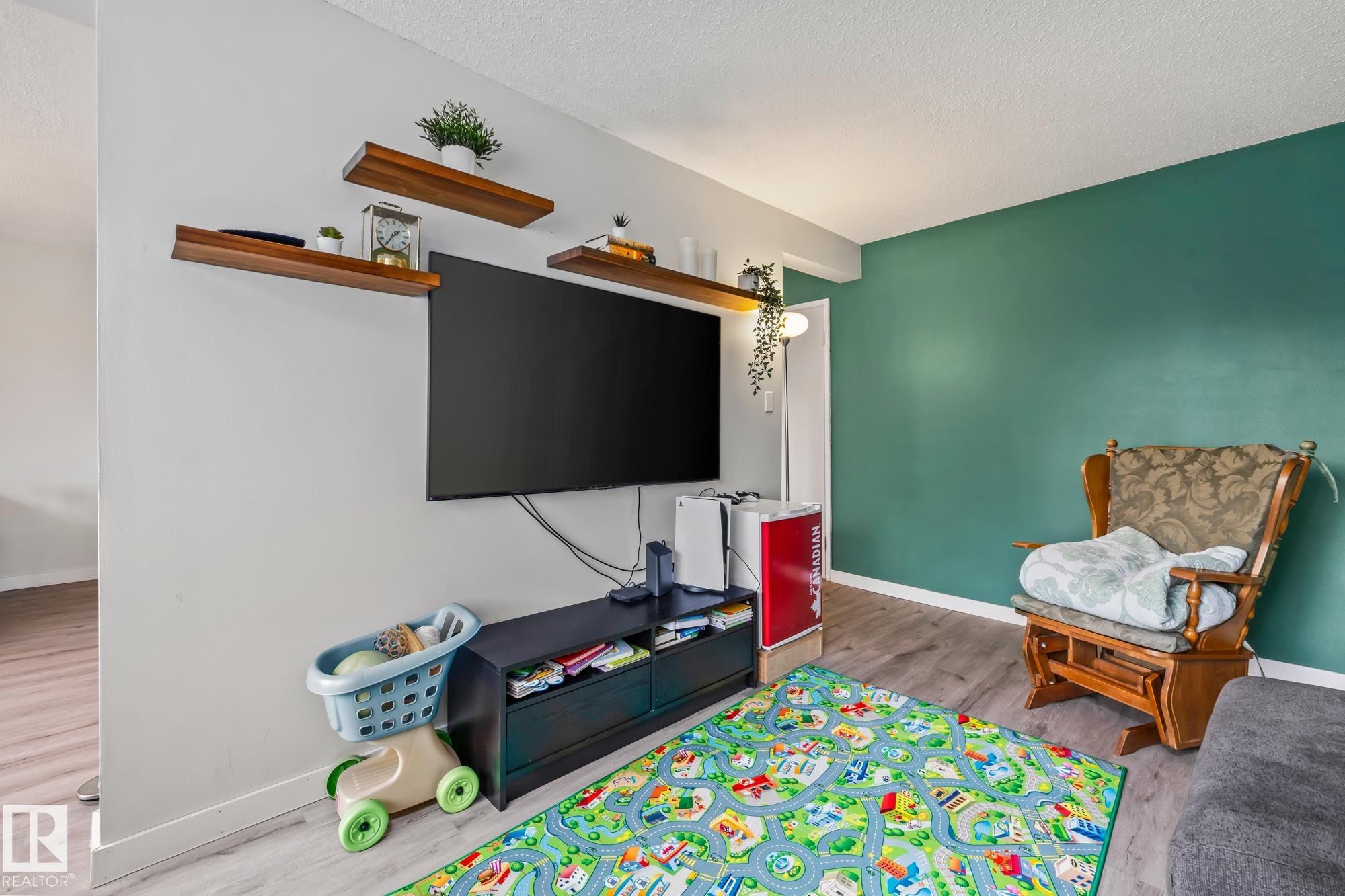 Recreation room featuring wood finished floors and a textured ceiling - 11 Grandview Ridge, St. Albert, AB - Indoor