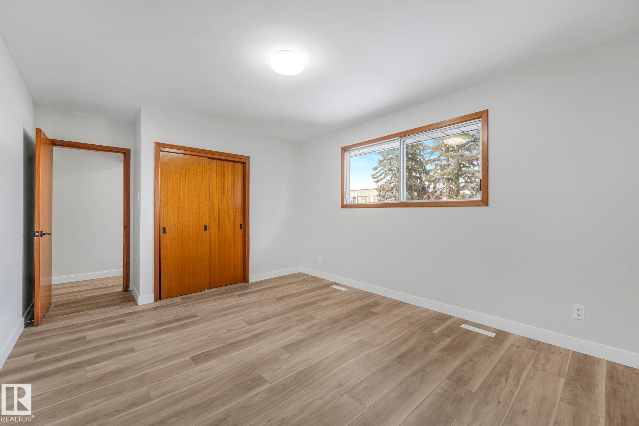 Unfurnished bedroom featuring light wood finished floors and a closet - 6007 95 Avenue, Edmonton, AB - Indoor Photo Showing Other Room