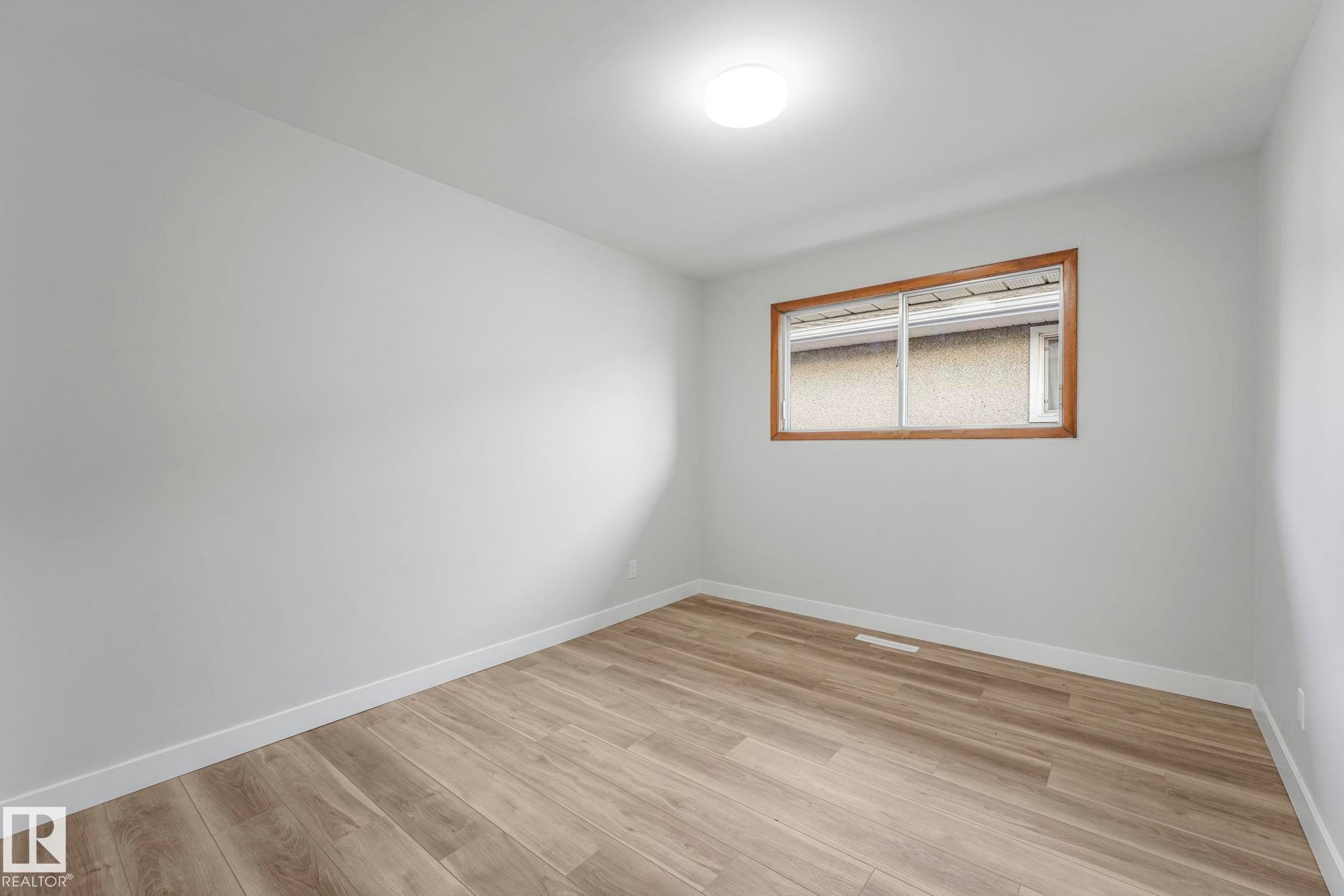 Spare room featuring light wood-style flooring and baseboards - 6007 95 Avenue, Edmonton, AB - Indoor Photo Showing Other Room