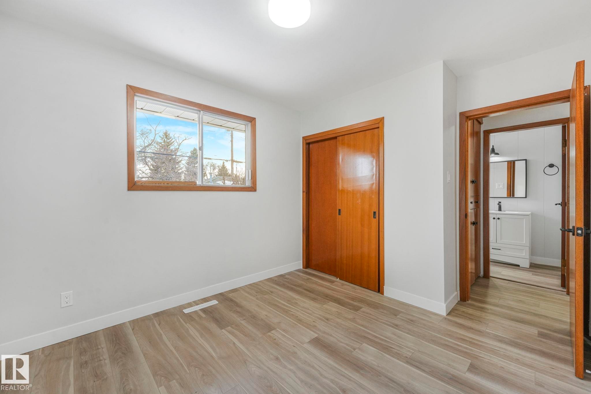 Unfurnished bedroom featuring light wood-style flooring and a closet - 6007 95 Avenue, Edmonton, AB - Indoor Photo Showing Other Room