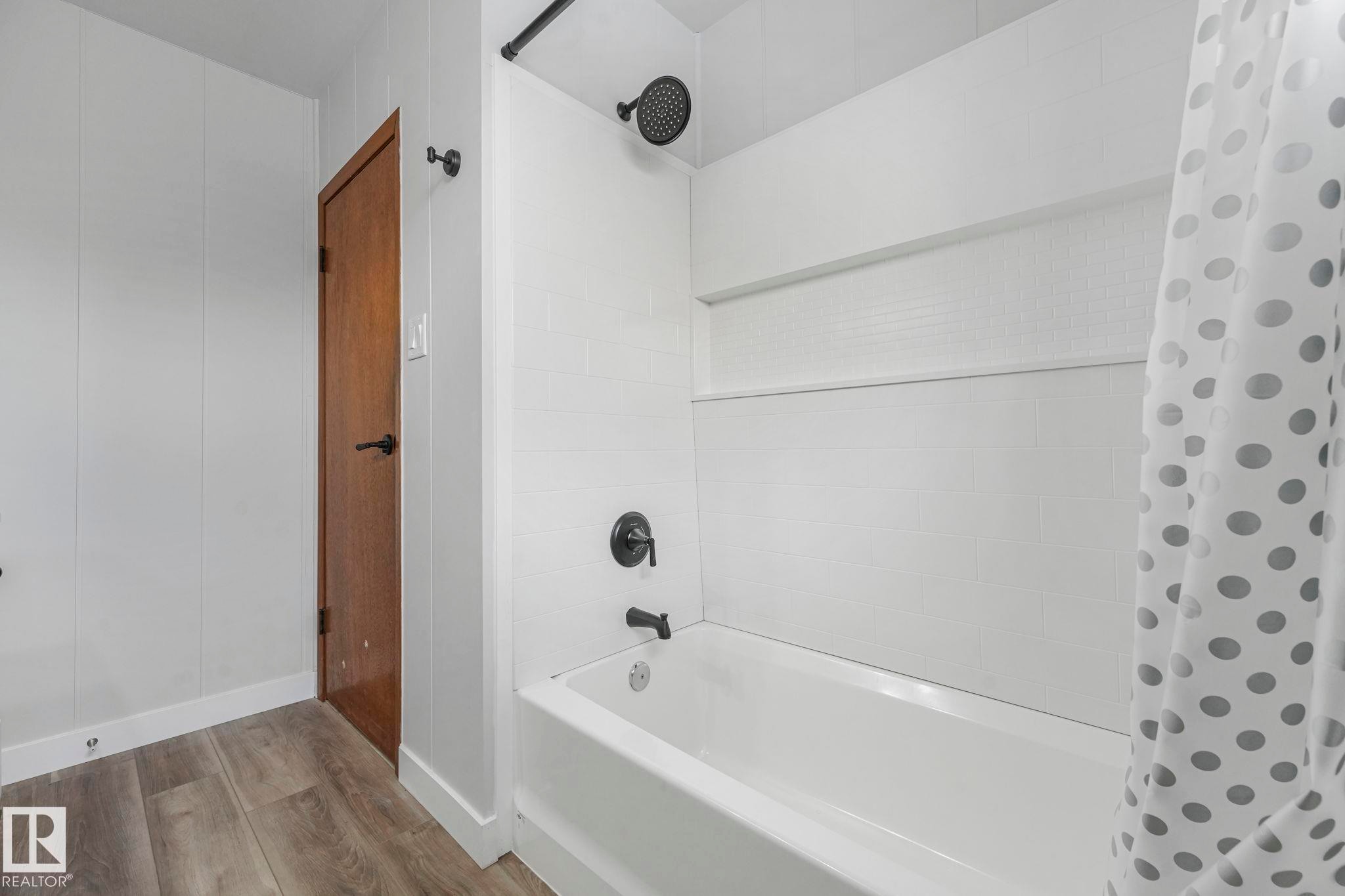 Full bath featuring shower / tub combo with curtain and wood finished floors - 6007 95 Avenue, Edmonton, AB - Indoor Photo Showing Bathroom
