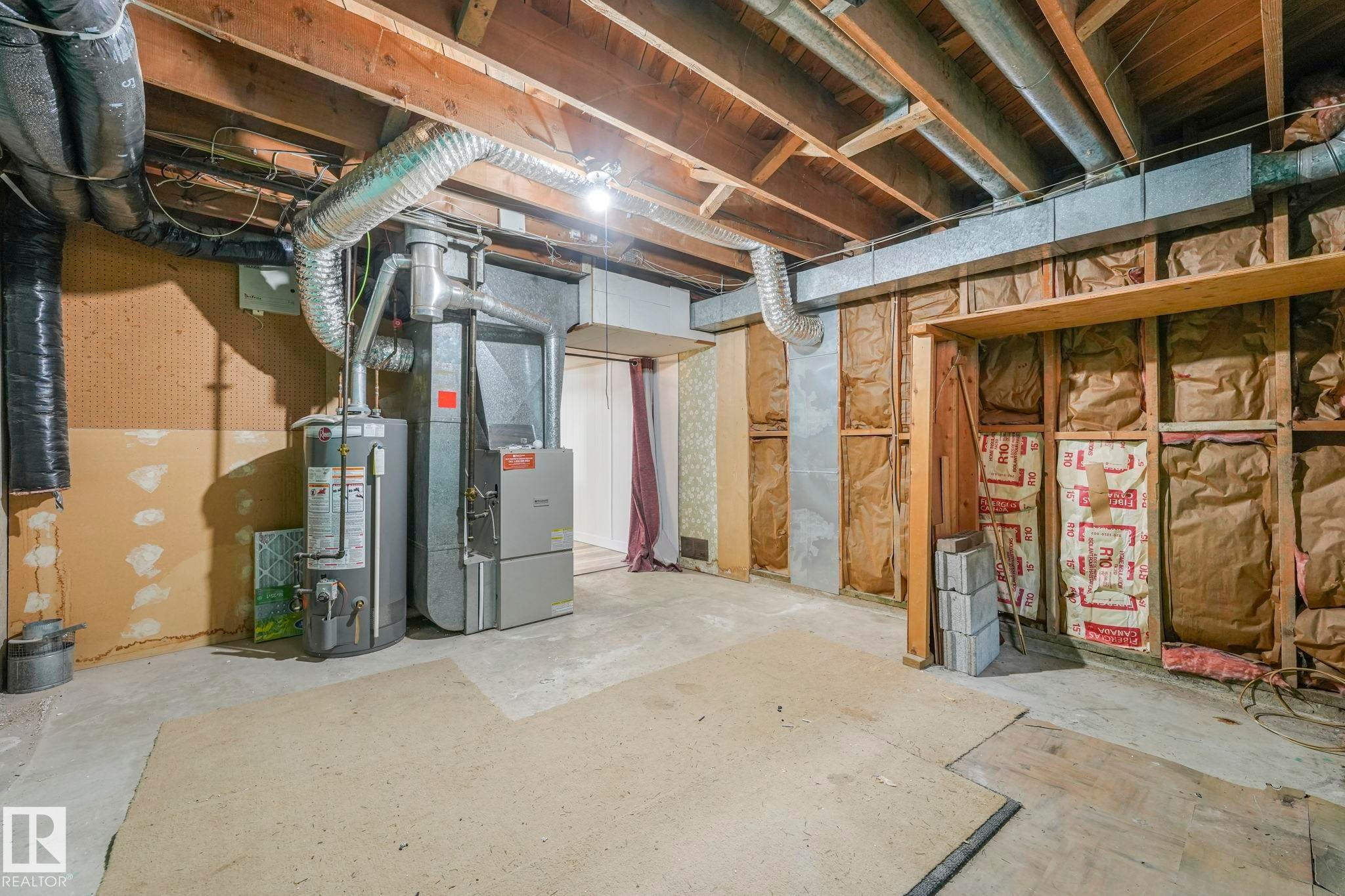Unfinished basement with water heater and heating unit - 6007 95 Avenue, Edmonton, AB - Indoor Photo Showing Basement
