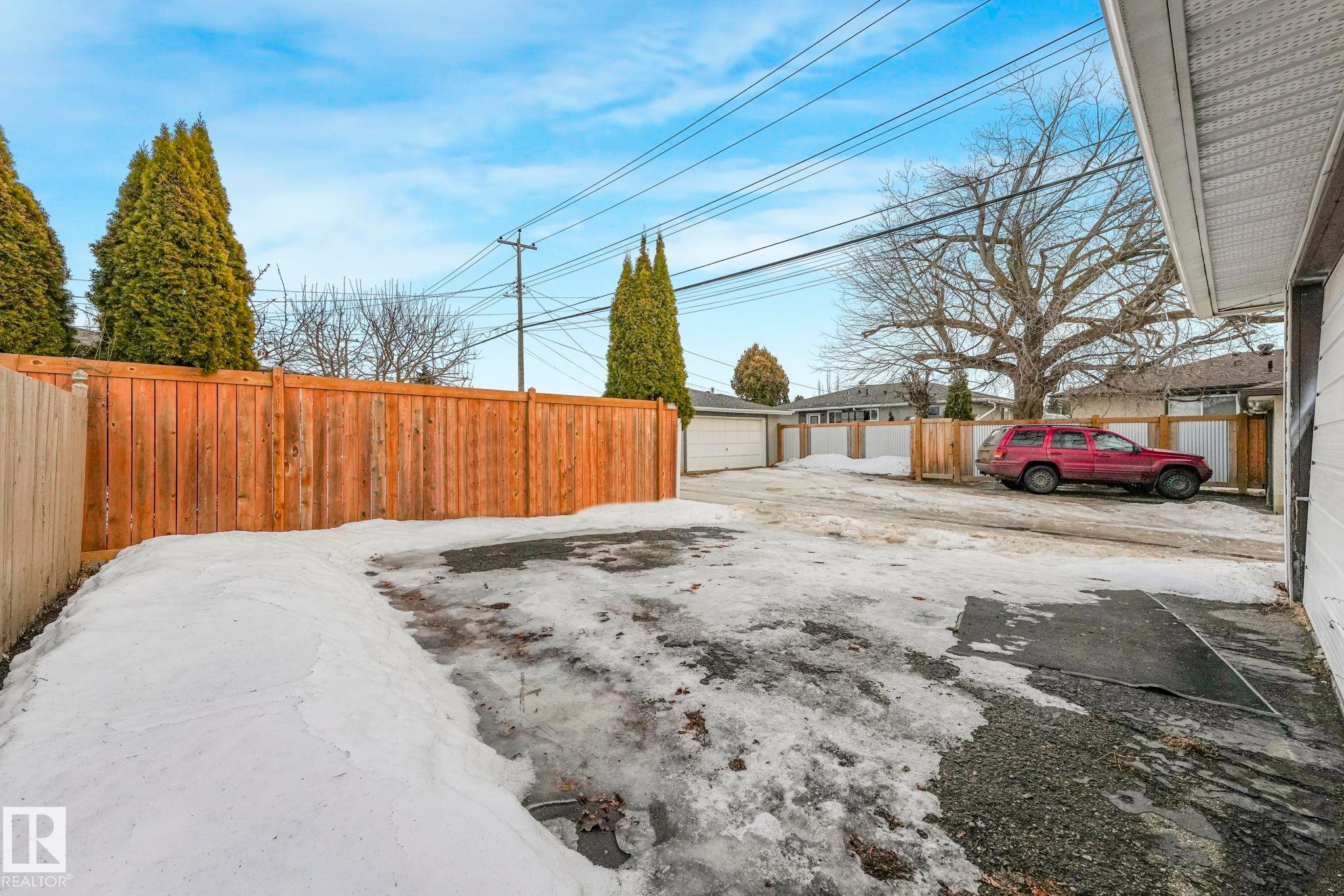 Fenced backyard featuring an outdoor structure and a garage - 6007 95 Avenue, Edmonton, AB - Outdoor