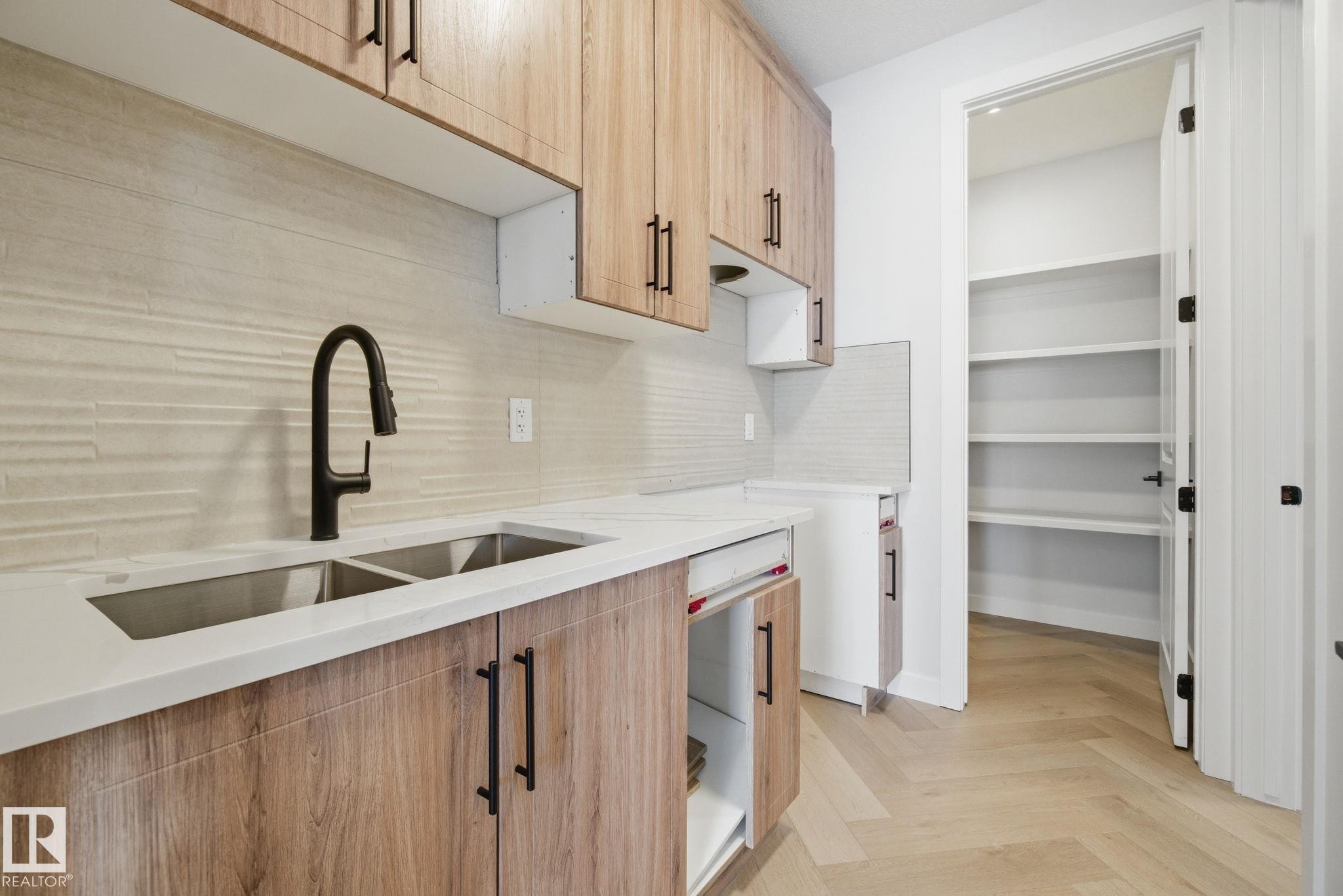 Kitchen with parquet flooring, light wood finish cabinetry, light stone countertops, and backsplash - 17108 2 Street, Edmonton, AB - Indoor Photo Showing Kitchen With Double Sink With Upgraded Kitchen