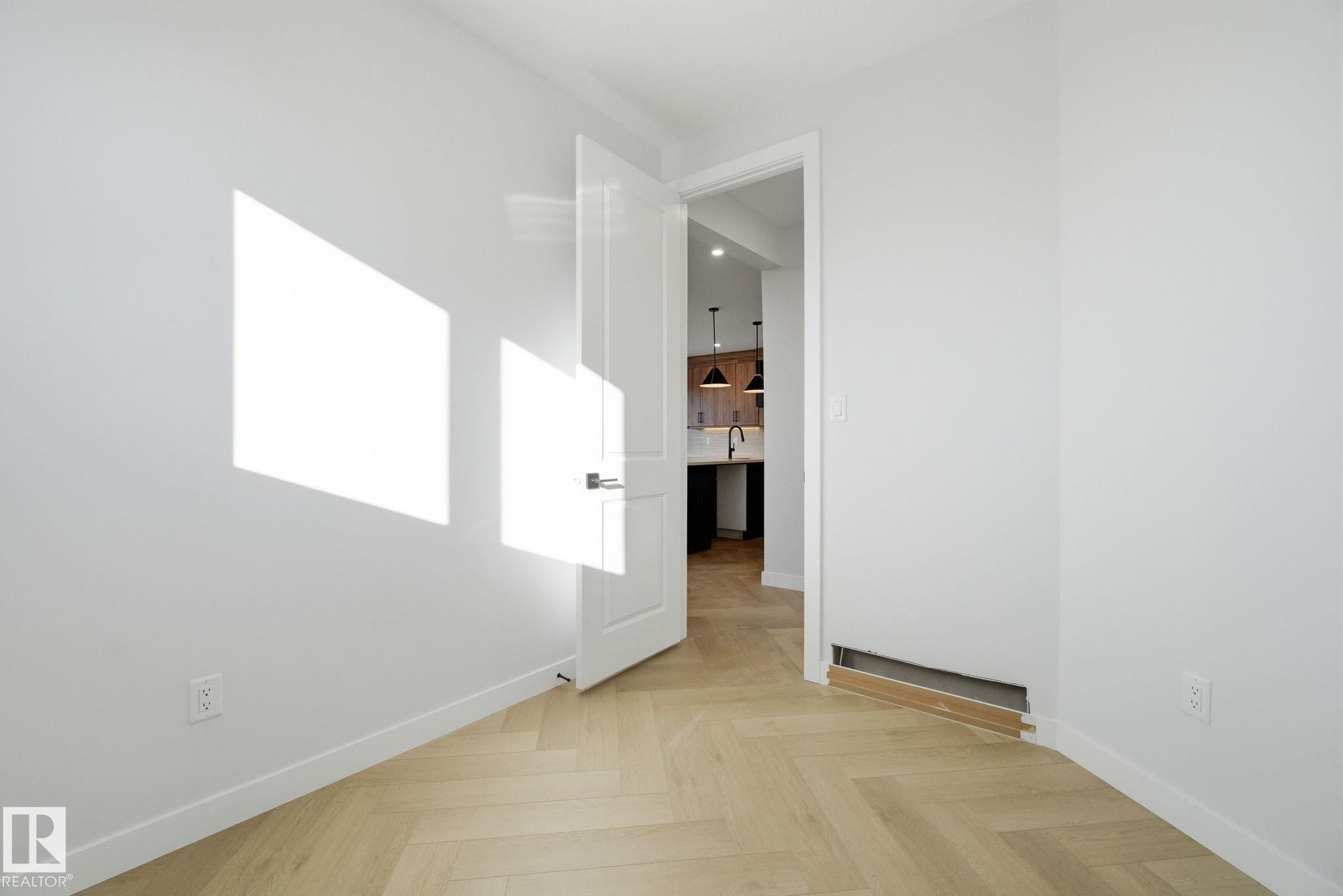 Unfurnished room featuring parquet floors and baseboards - 17108 2 Street, Edmonton, AB - Indoor Photo Showing Other Room