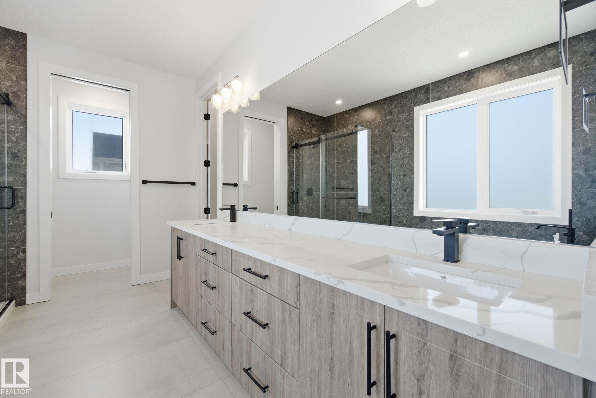 Bathroom featuring a stall shower, double vanity, and light tile patterned floors - 17108 2 Street, Edmonton, AB - Indoor Photo Showing Bathroom