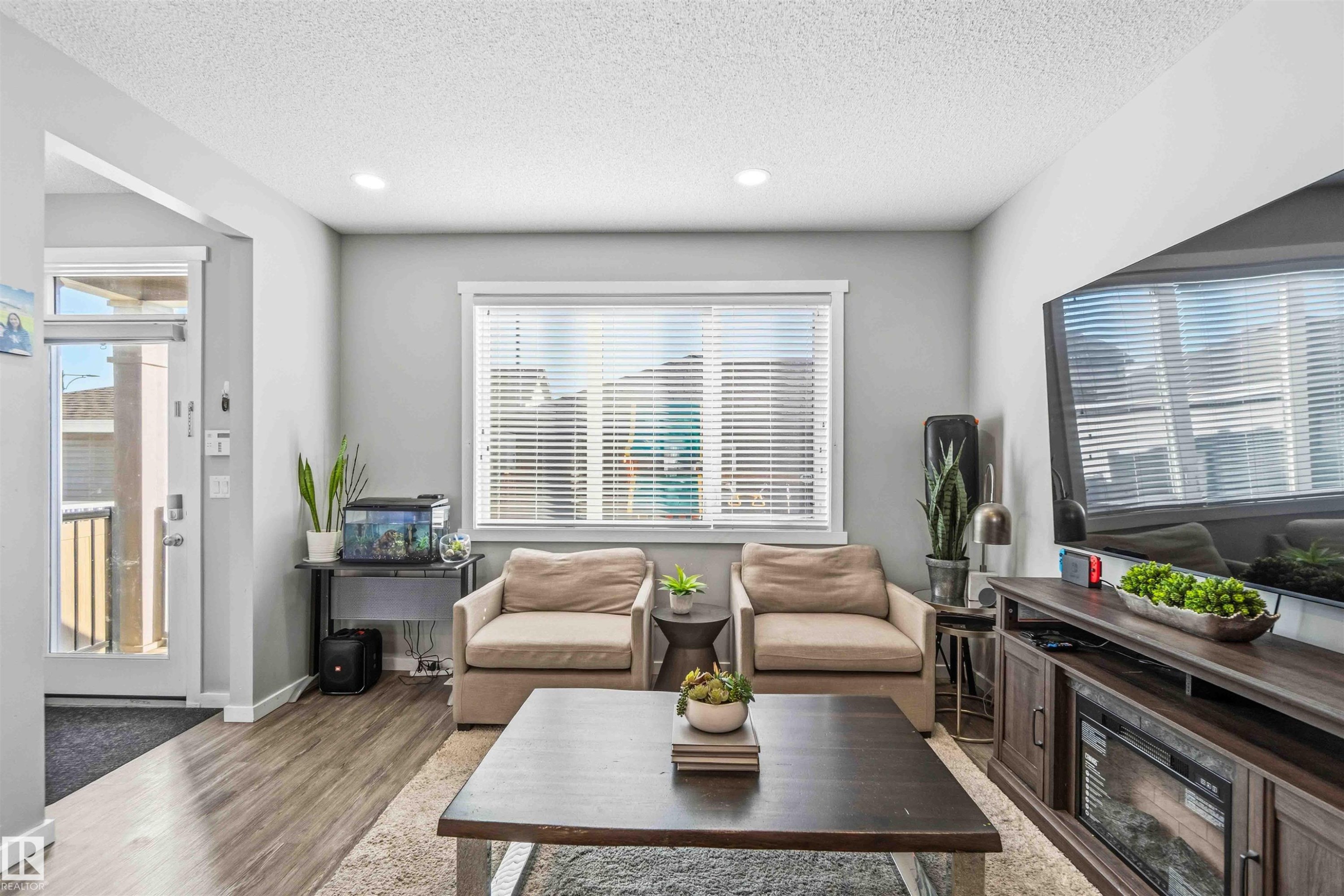 Living room featuring wood finished floors, a textured ceiling, and recessed lighting - 1908 25 Street, Edmonton, AB - Indoor Photo Showing Living Room