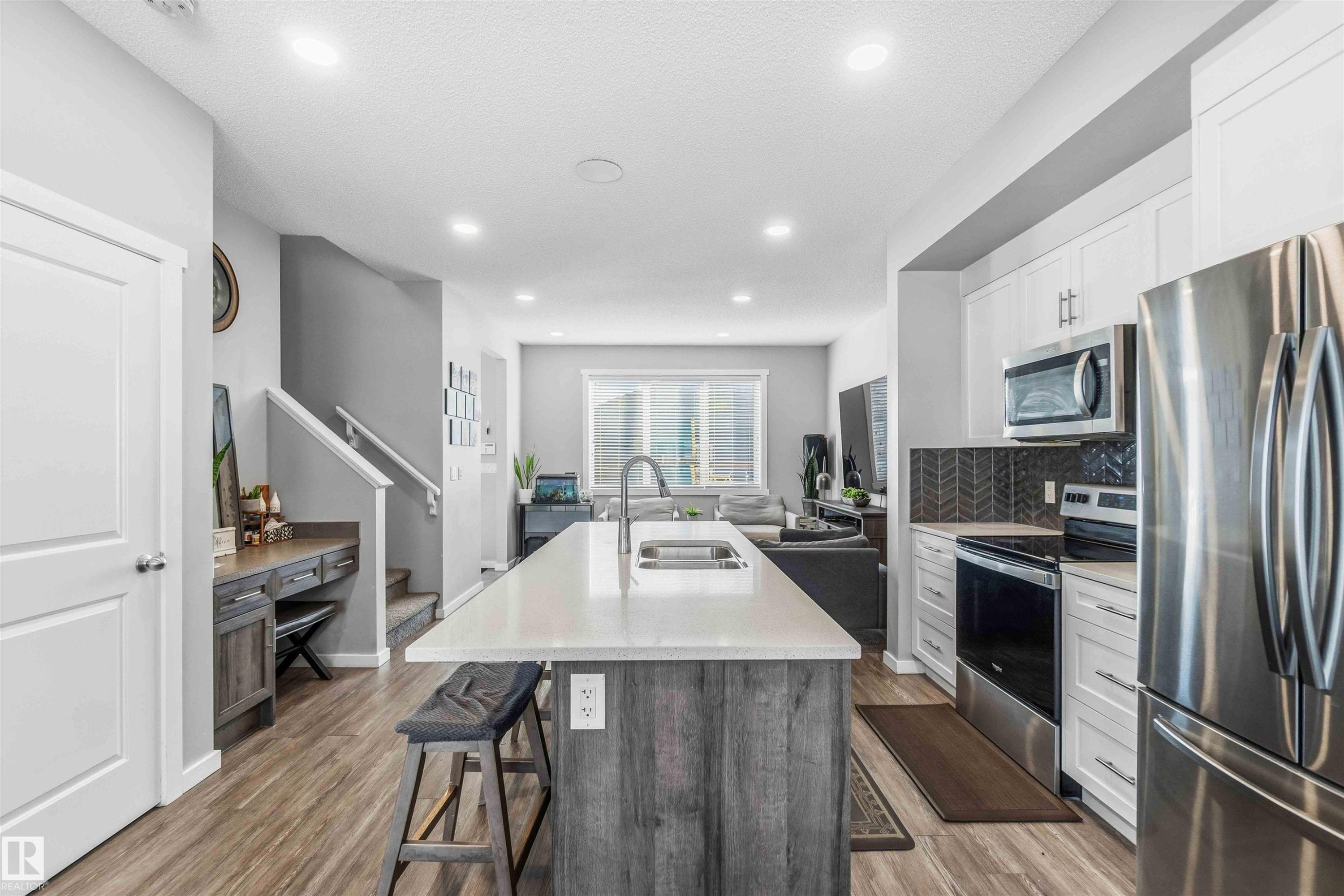Kitchen featuring stainless steel appliances, a center island with sink, open floor plan, light wood-type flooring, and recessed lighting - 1908 25 Street, Edmonton, AB - Indoor Photo Showing Kitchen With Stainless Steel Kitchen With Double Sink With Upgraded Kitchen