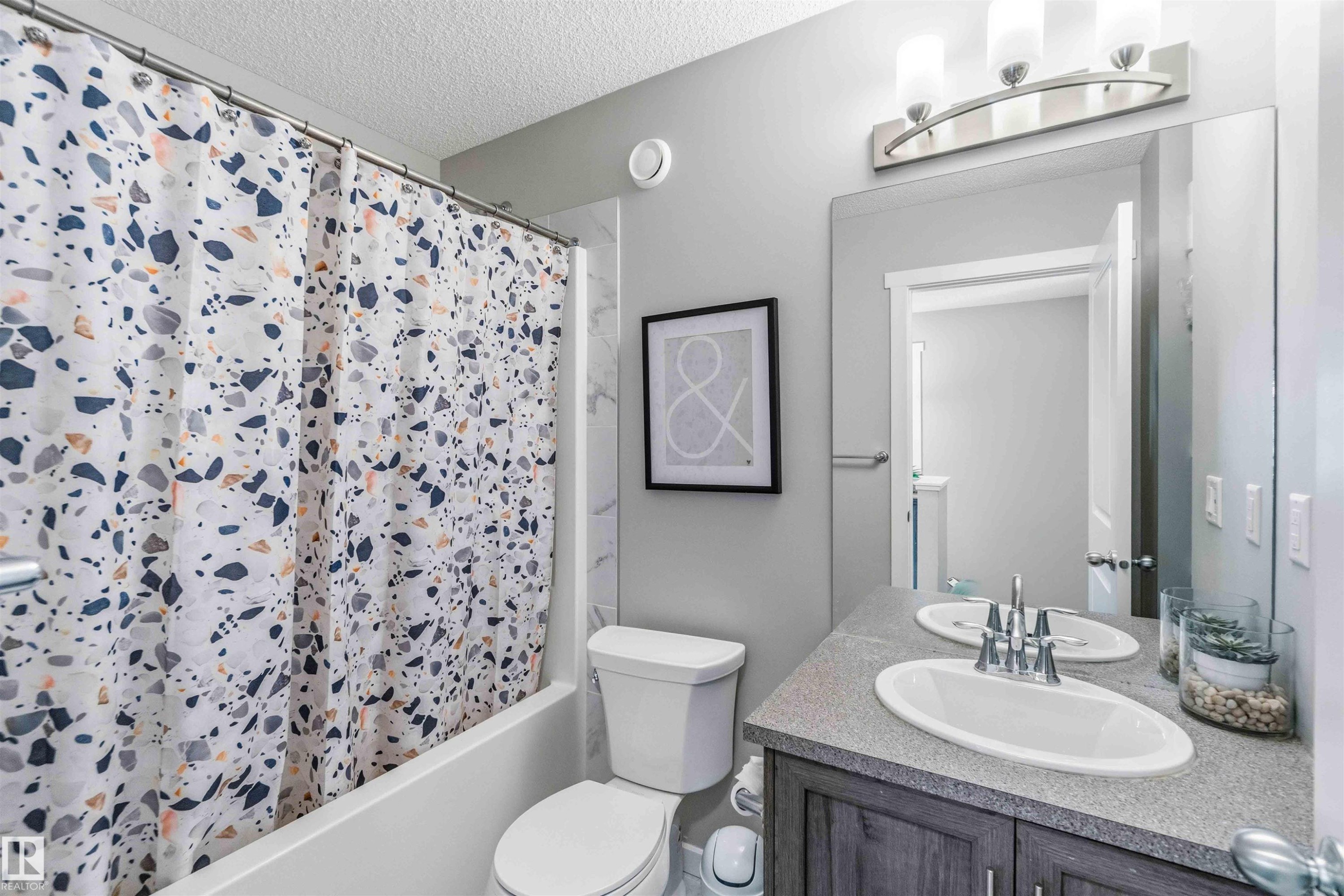 Full bathroom featuring vanity, a textured ceiling, and shower / bath combo - 1908 25 Street, Edmonton, AB - Indoor Photo Showing Bathroom