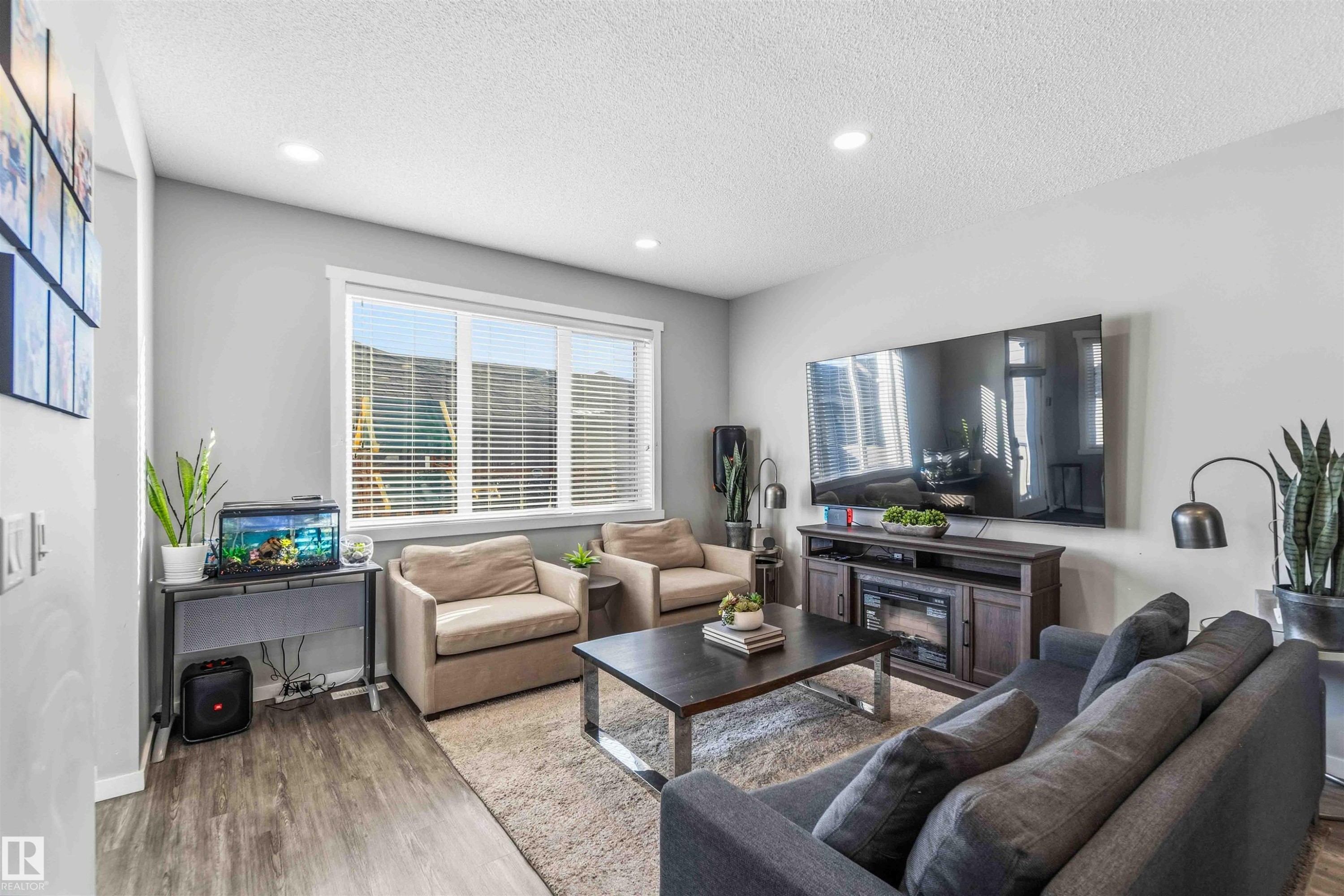 Living area featuring wood finished floors, a textured ceiling, and recessed lighting - 1908 25 Street, Edmonton, AB - Indoor Photo Showing Living Room
