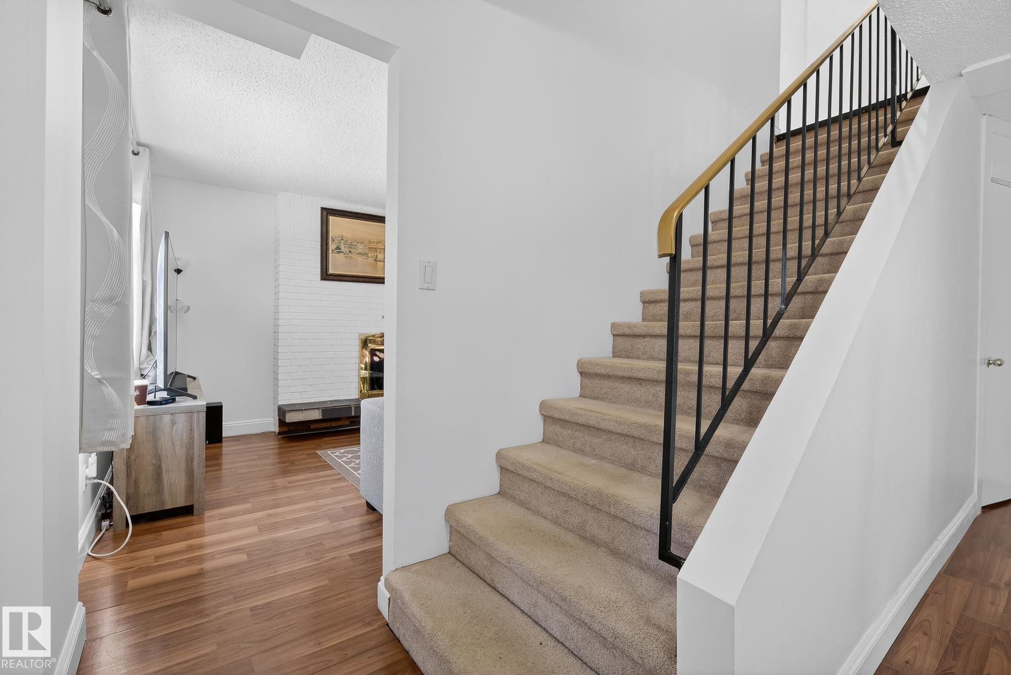Stairway featuring wood finished floors and a textured ceiling - 10602 66 Avenue, Edmonton, AB - Indoor Photo Showing Other Room