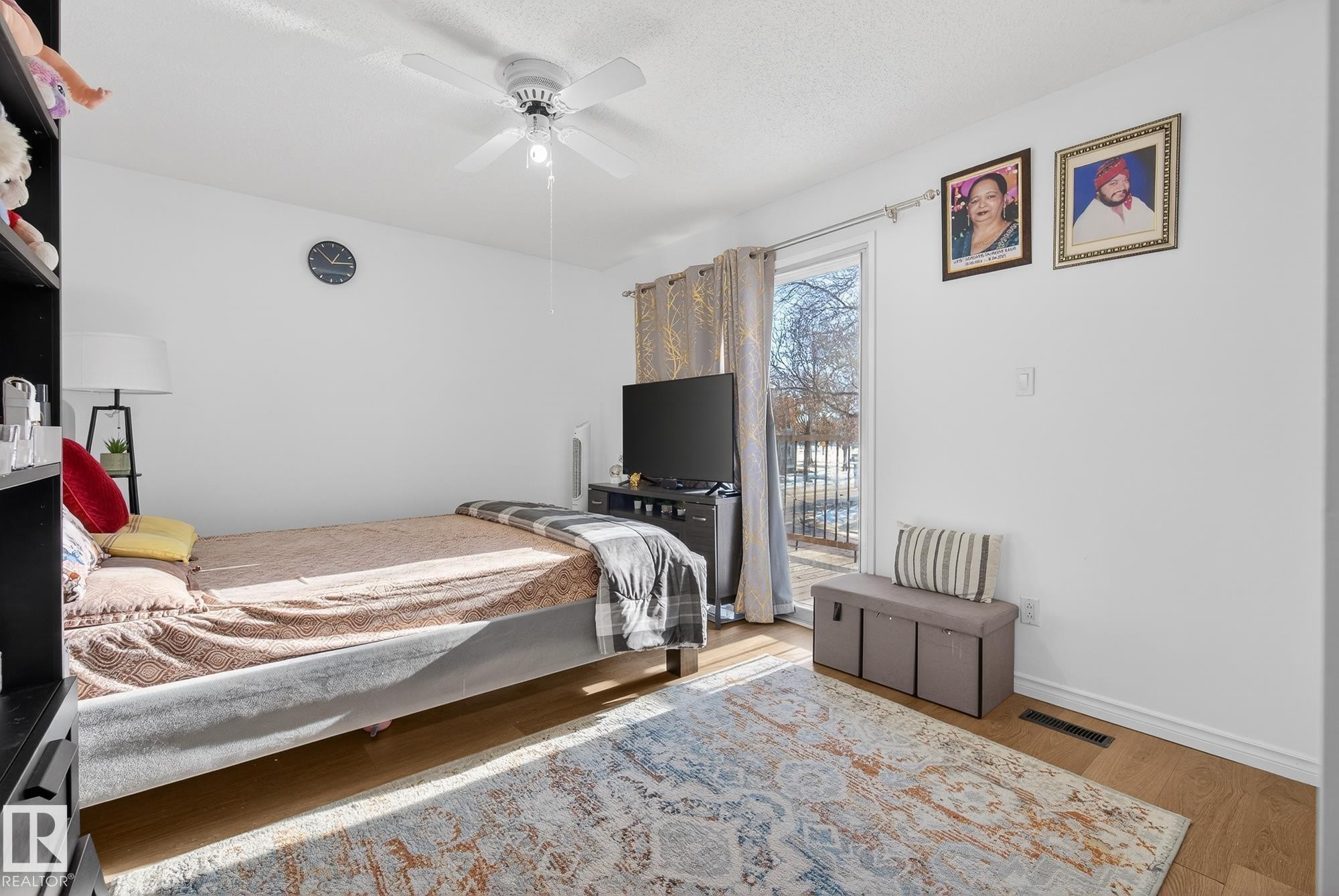 Bedroom featuring ceiling fan, wood finished floors, access to exterior, and a textured ceiling - 10602 66 Avenue, Edmonton, AB - Indoor Photo Showing Bedroom