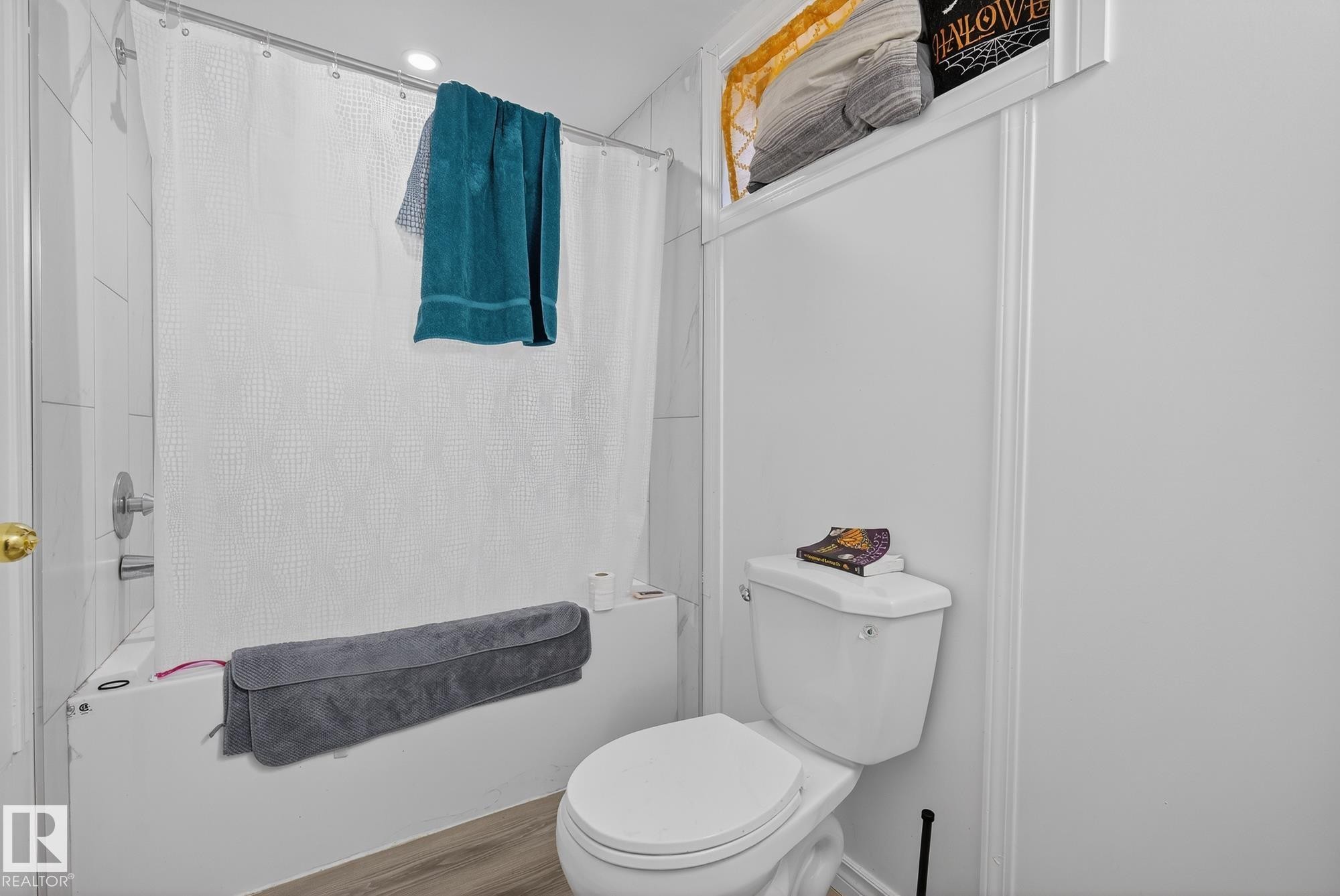 Full bath featuring shower / tub combo with curtain and wood finished floors - 10602 66 Avenue, Edmonton, AB - Indoor Photo Showing Bathroom