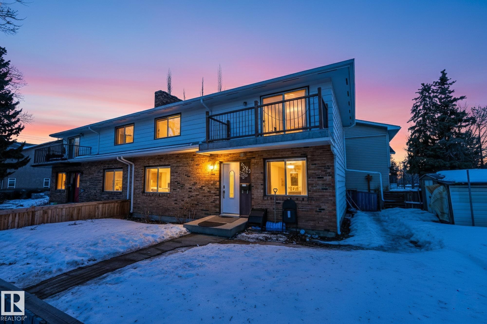 Snow covered rear of property with a chimney, an outdoor structure, a balcony, and brick siding - 10602 66 Avenue, Edmonton, AB - Outdoor