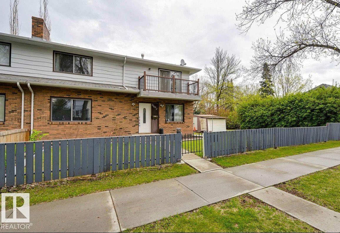 View of front facade with a balcony, brick siding, a fenced front yard, and a chimney - 10602 66 Avenue, Edmonton, AB - Outdoor