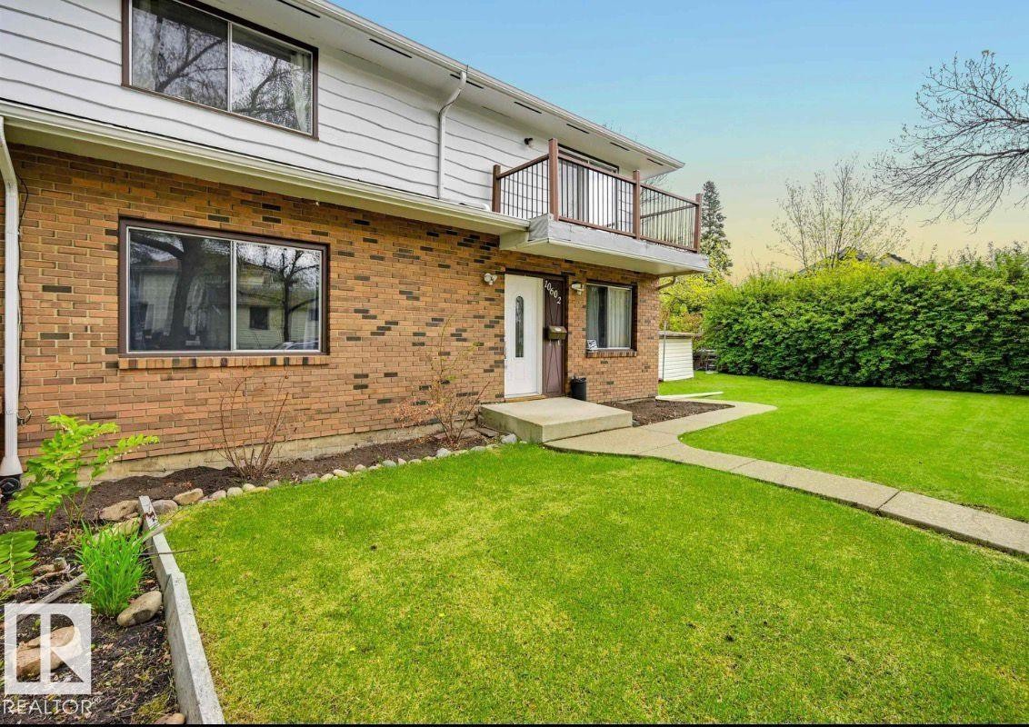 View of front of home with a yard, a balcony, and brick siding - 10602 66 Avenue, Edmonton, AB - Outdoor
