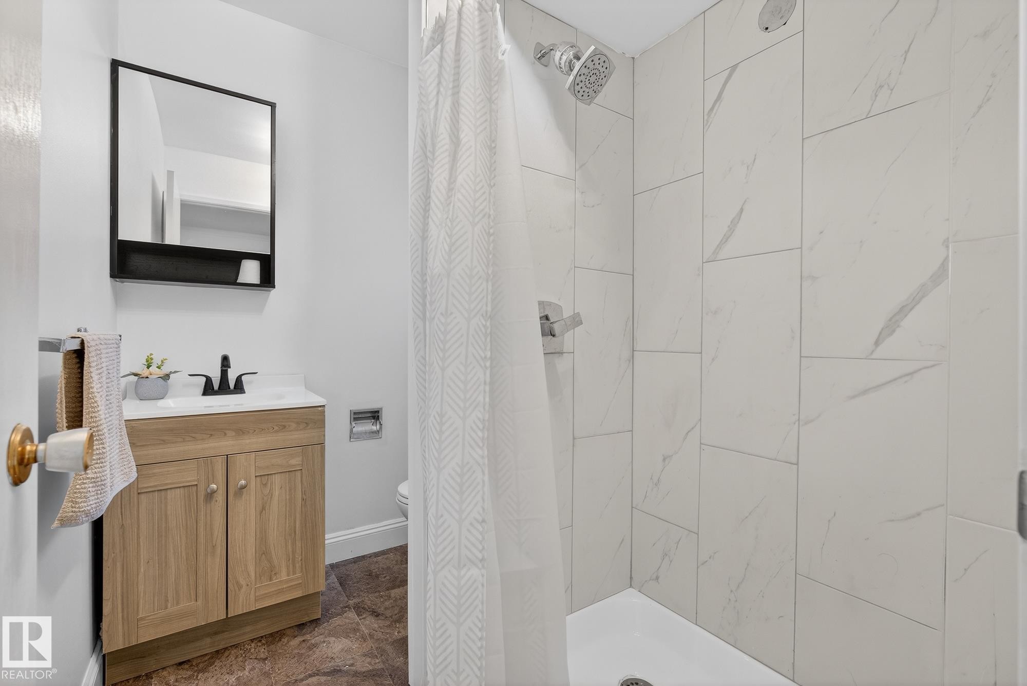 Full bath with a shower stall, vanity, and dark stone finish floors - 10602 66 Avenue, Edmonton, AB - Indoor Photo Showing Bathroom