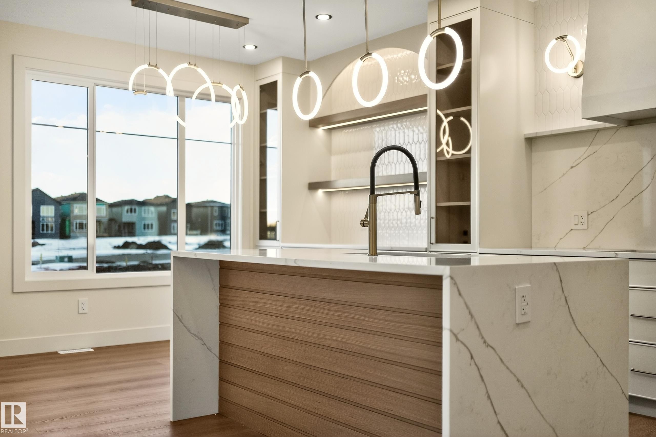 Kitchen with modern cabinets, light stone countertops, light wood-style flooring, and pendant lighting - 8924 Mayday Way, Edmonton, AB