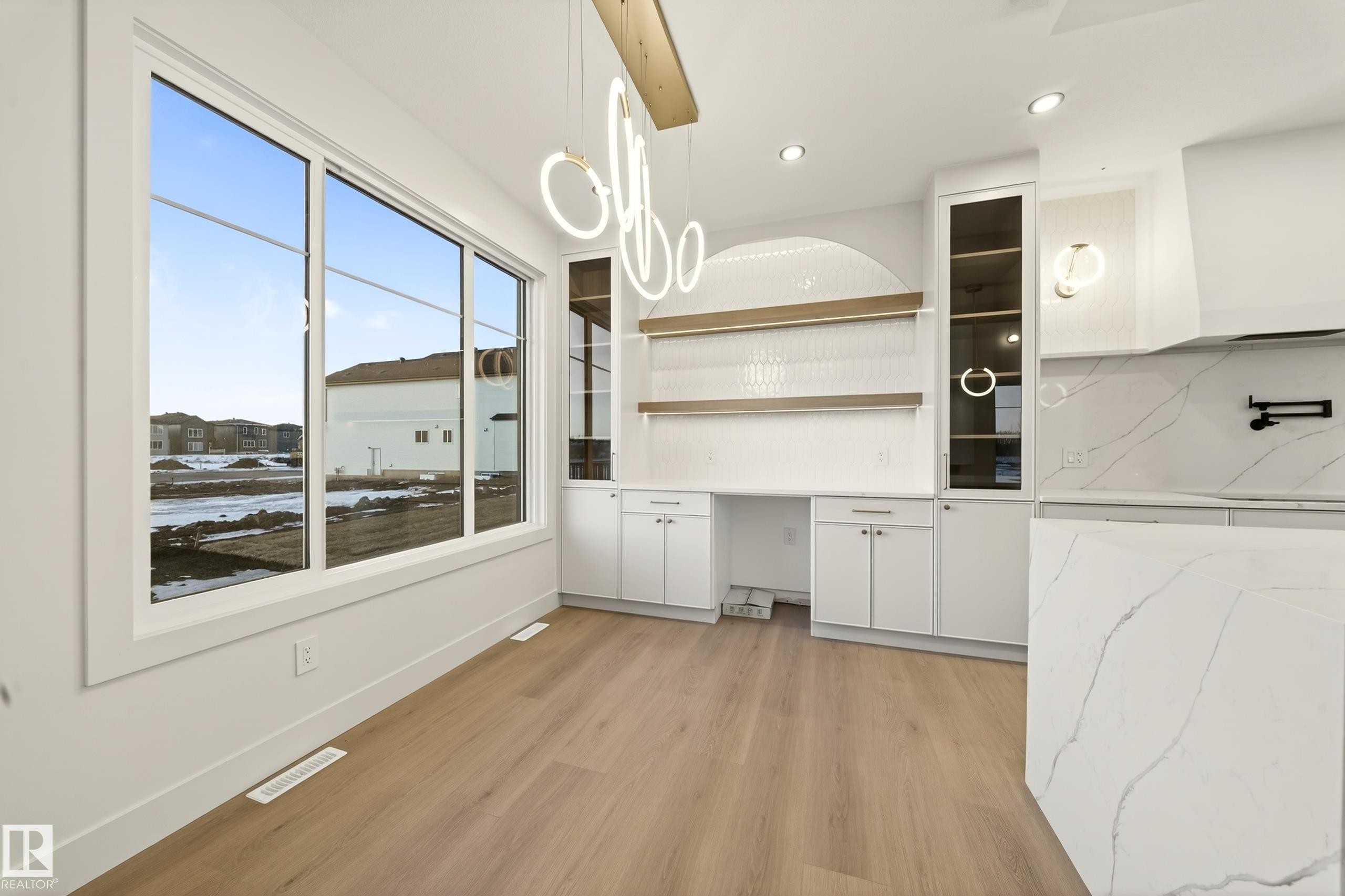 Unfurnished dining area featuring light wood-style flooring, recessed lighting, and built in study area - 8924 Mayday Way, Edmonton, AB