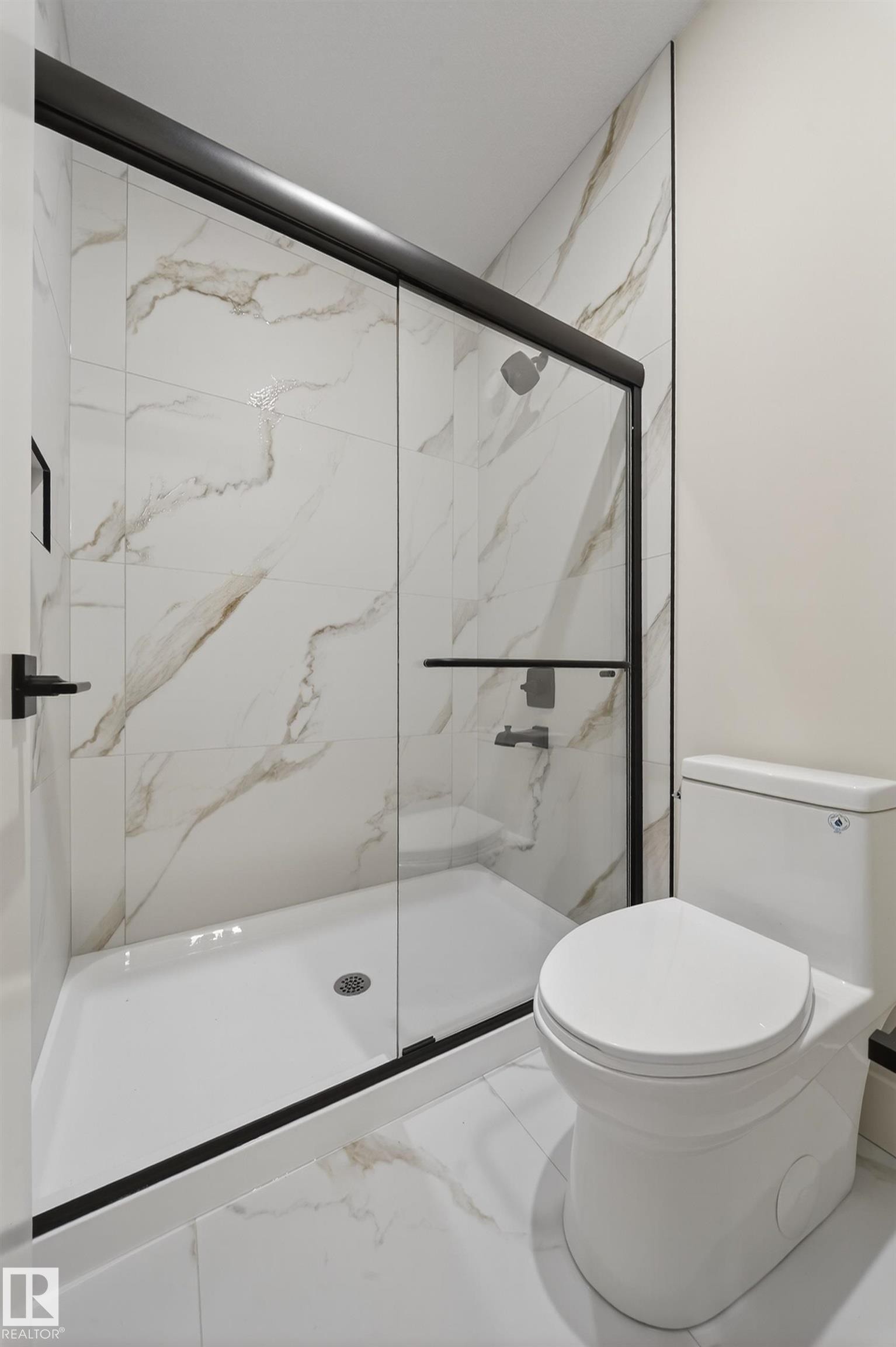 Full bath with a marble finish shower and marble look tile flooring - 8924 Mayday Way, Edmonton, AB - Indoor Photo Showing Bathroom