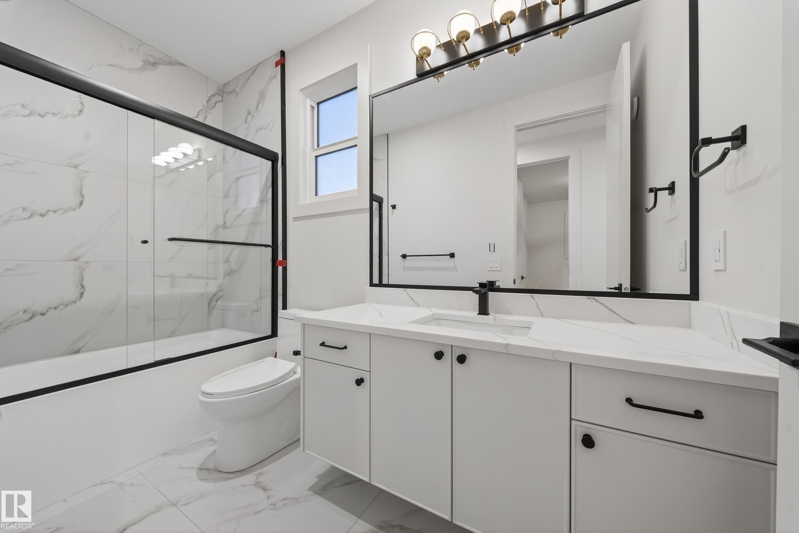 Full bath with vanity, shower / bath combination with glass door, and light marble finish floors - 8924 Mayday Way, Edmonton, AB - Indoor Photo Showing Bathroom