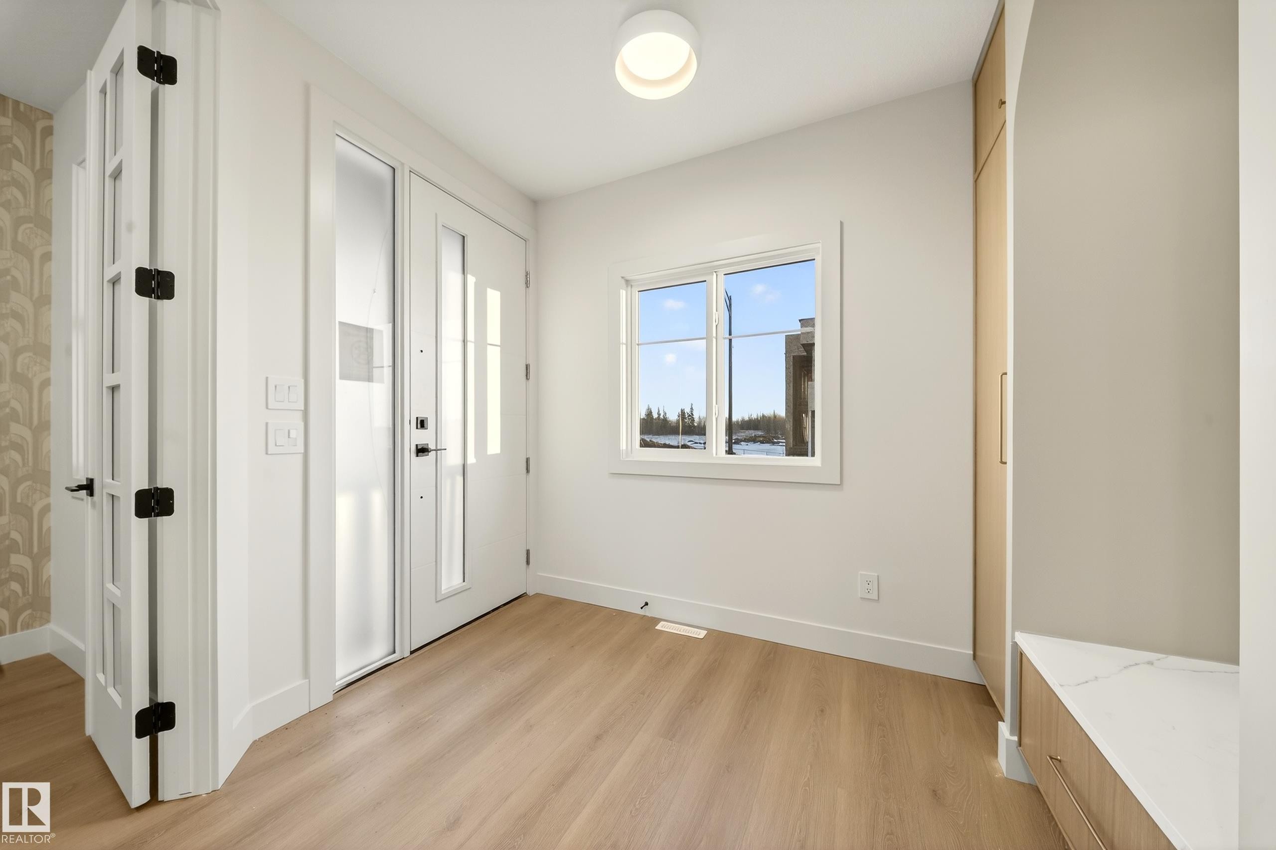 Entryway with light wood-style floors and baseboards - 8924 Mayday Way, Edmonton, AB